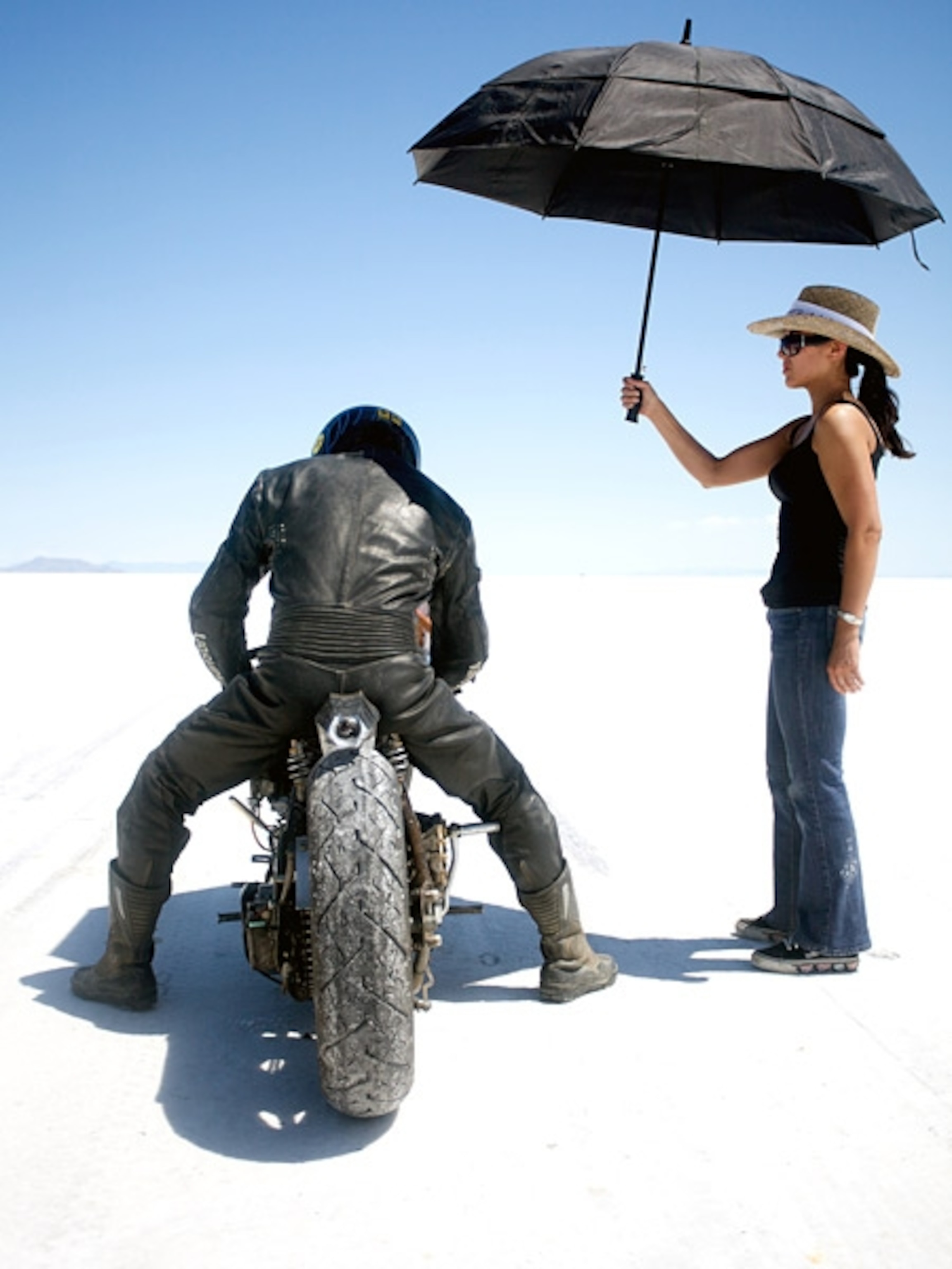Woman shades racer from sun with umbrella