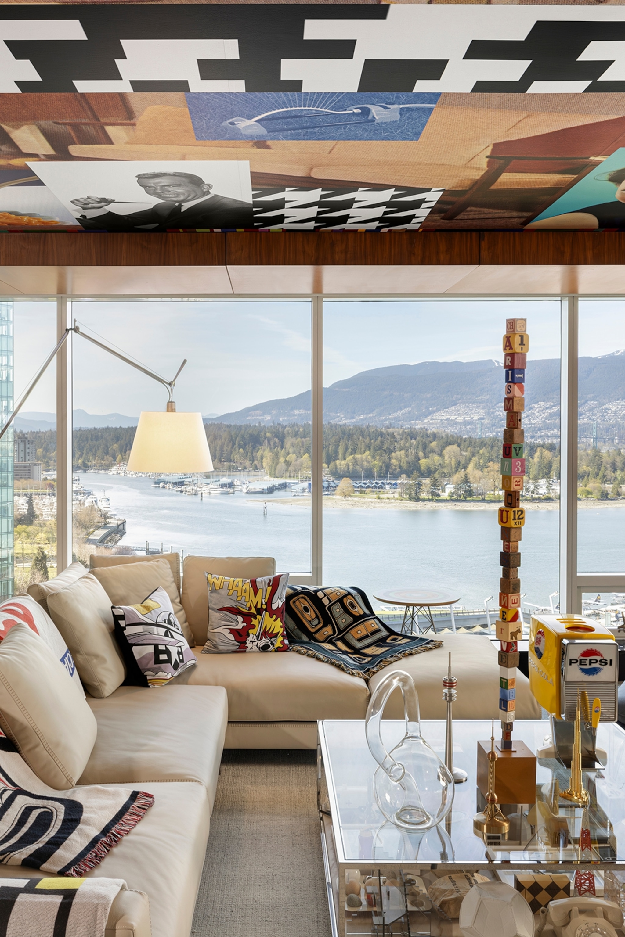 The living room of a hotel suite with panoramic views over Vancouver's floating Stanley Park, decorated with plenty of art objects.