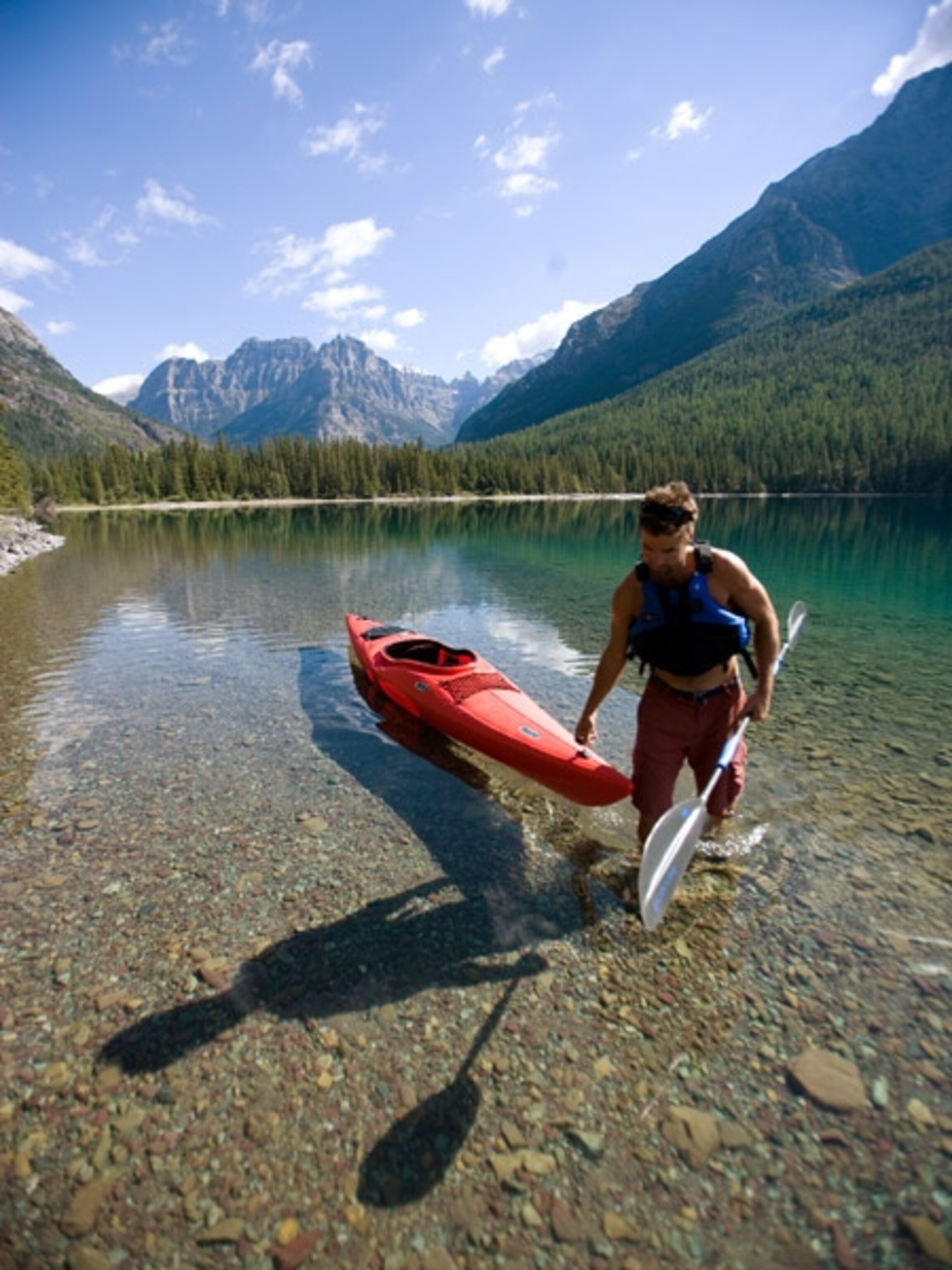 Man pulling kayak out of a shallow lake