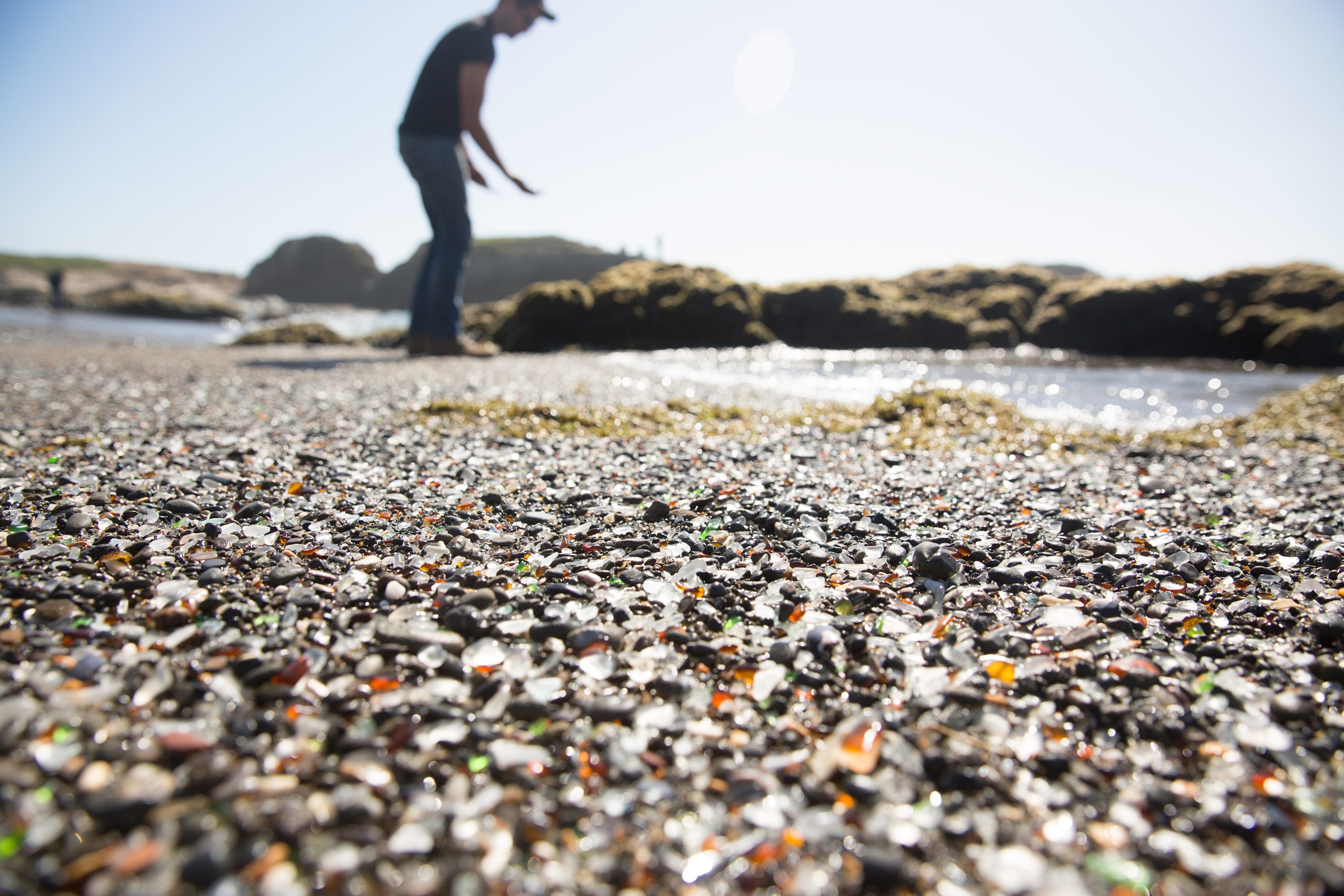 a man picking stones at Glass Beach, Mendocino County, California.
