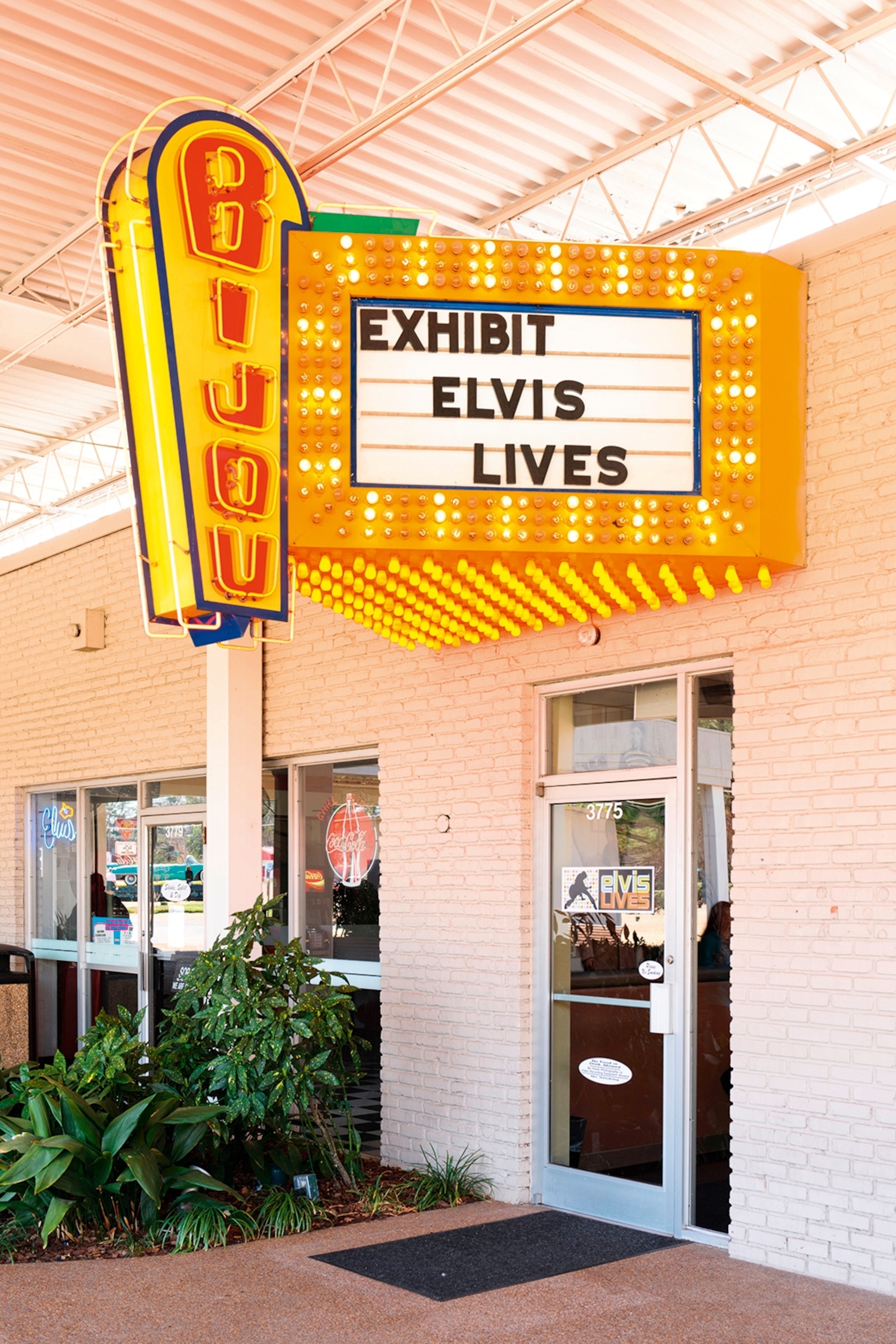 The entrance to a museum with a Las Vegas style neon sign and old cinema lettering.