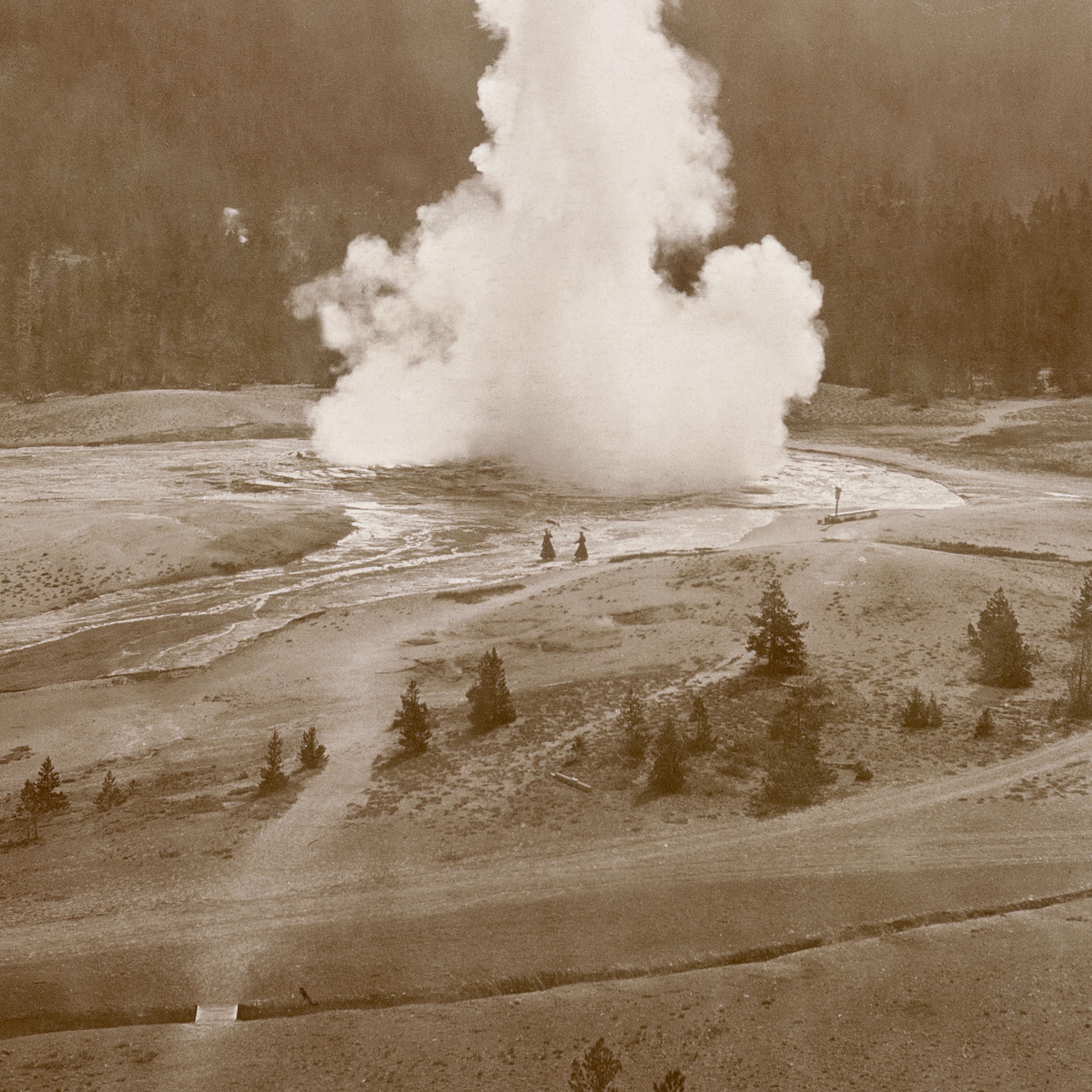 Detail of an archival photo showing two women walking near Yellowstone's Old Faithful geyser in 1919