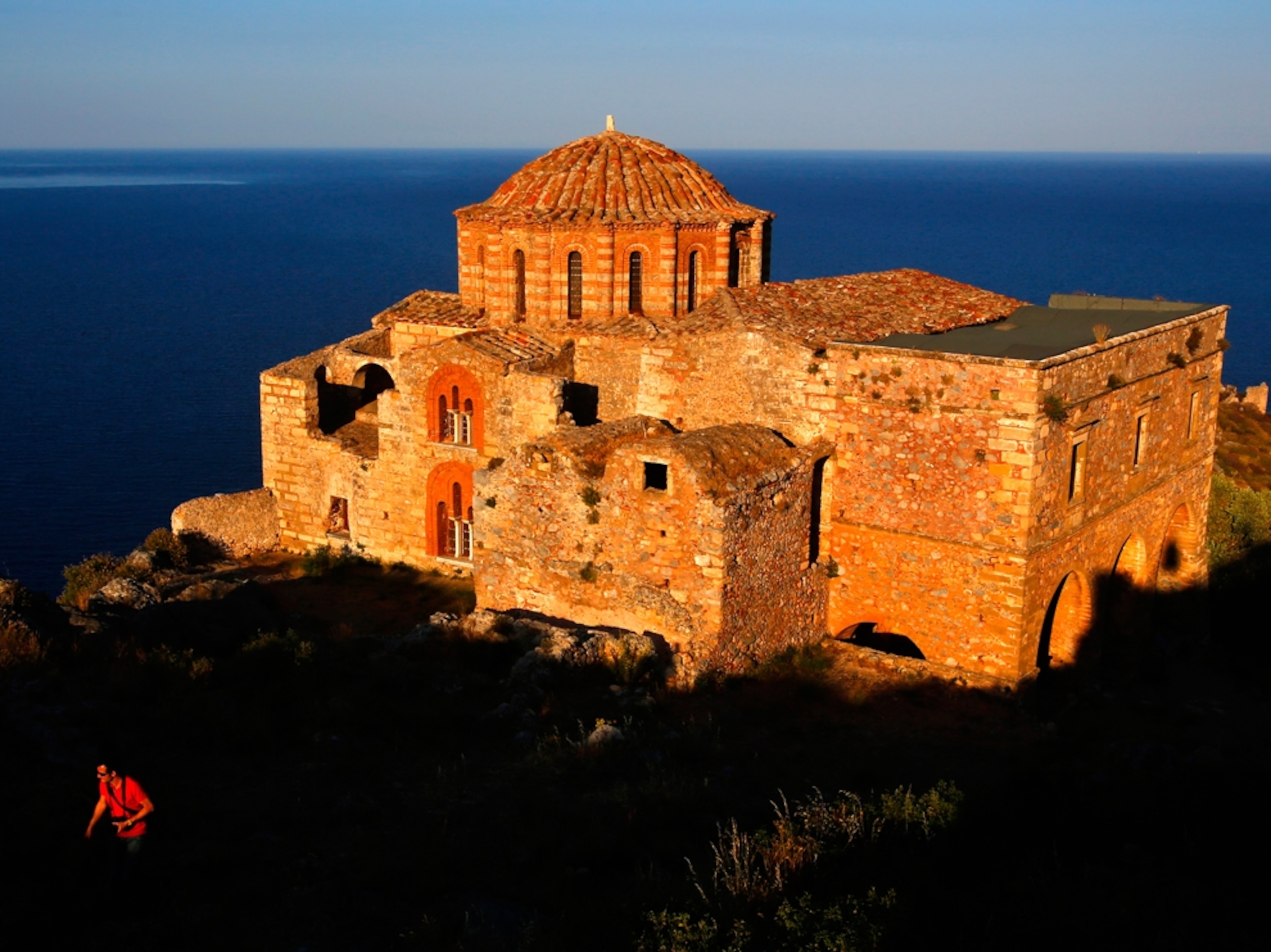 a tourist walking at sunset near the church of Agia Sophia, Greece