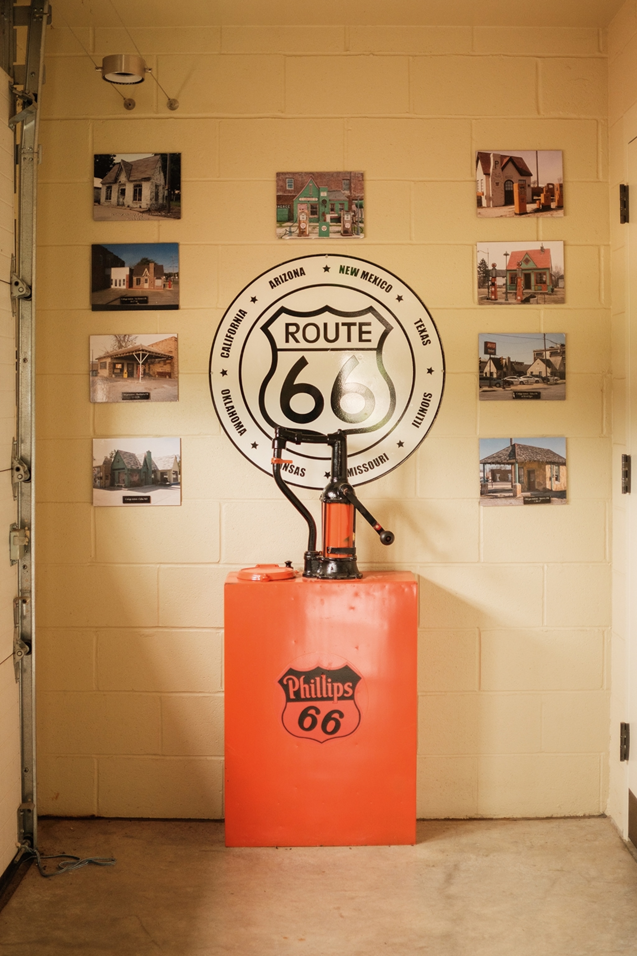 Ab old-school gas pump with a Route 66 logo on the wall behind it and images hung in a halo.