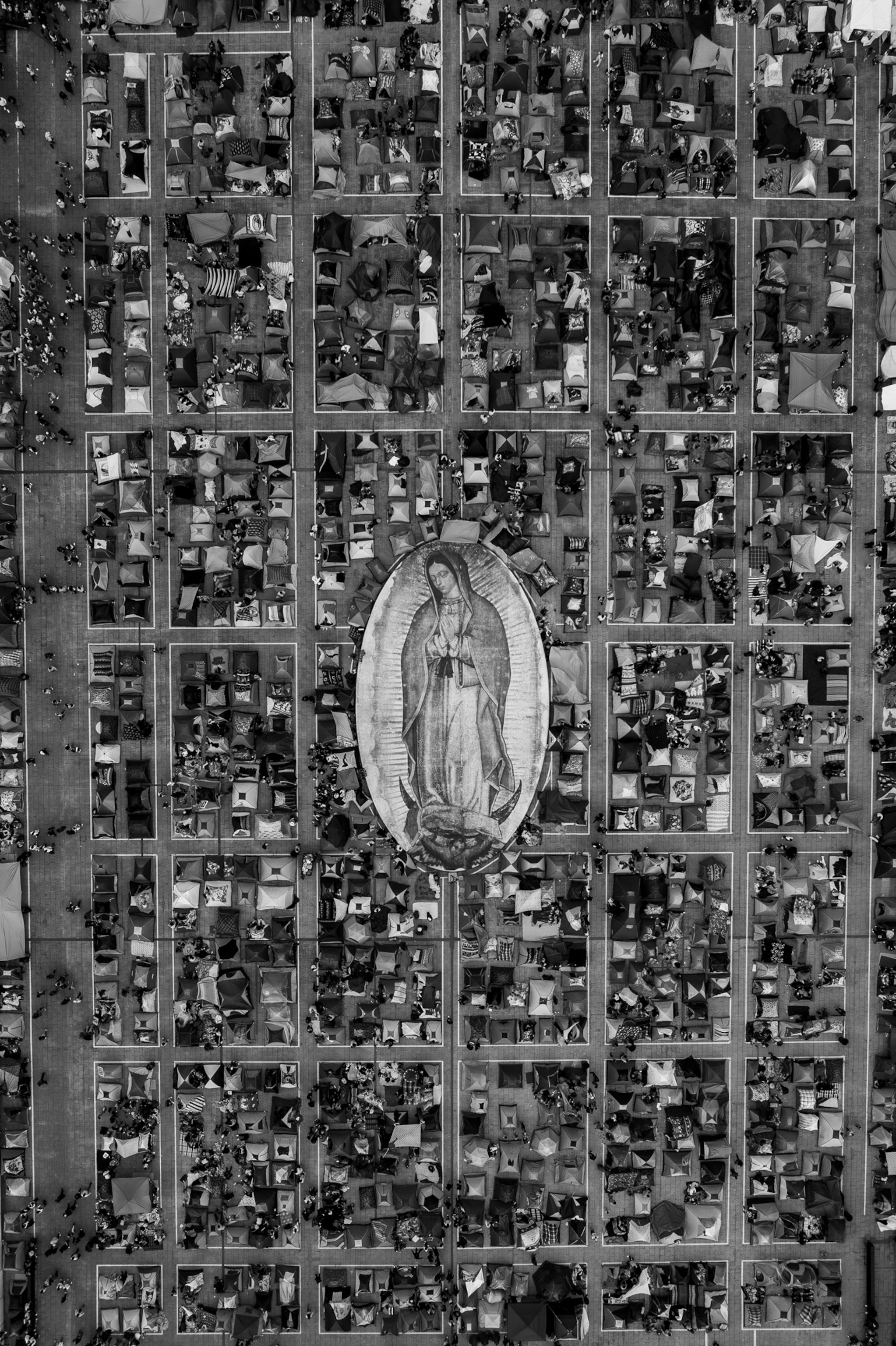 Aerial view of a large city with an image of a woman praying seen in the middle