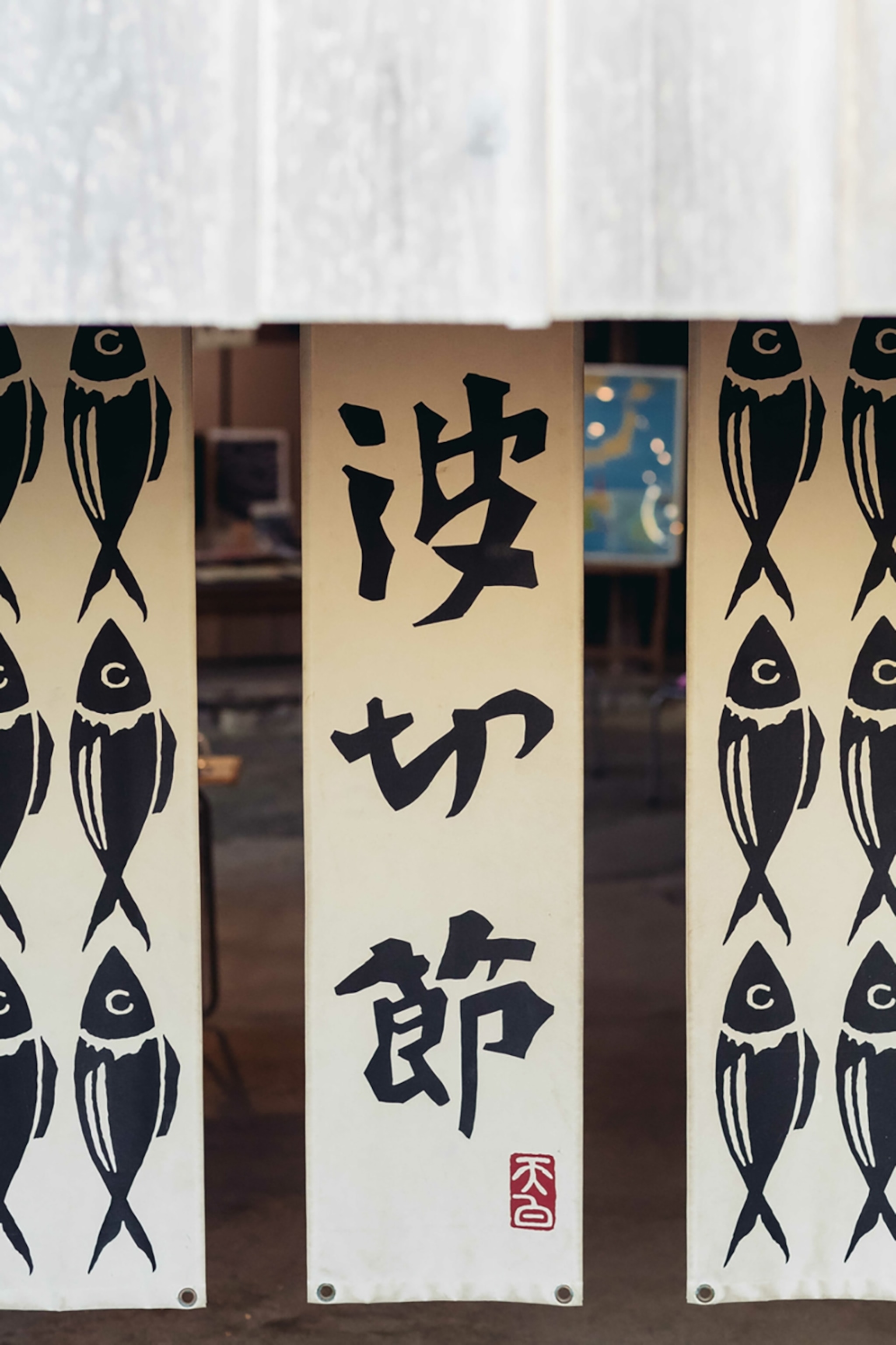 The entrance to a traditional Japanese restaurant with short curtains hung in the front door.