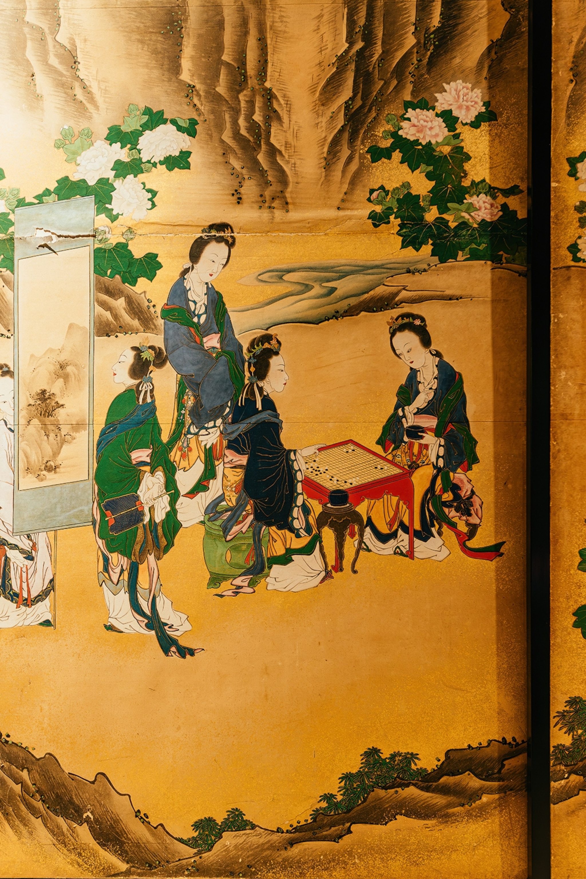 A close-up of a golden Japanese wood carved painting.