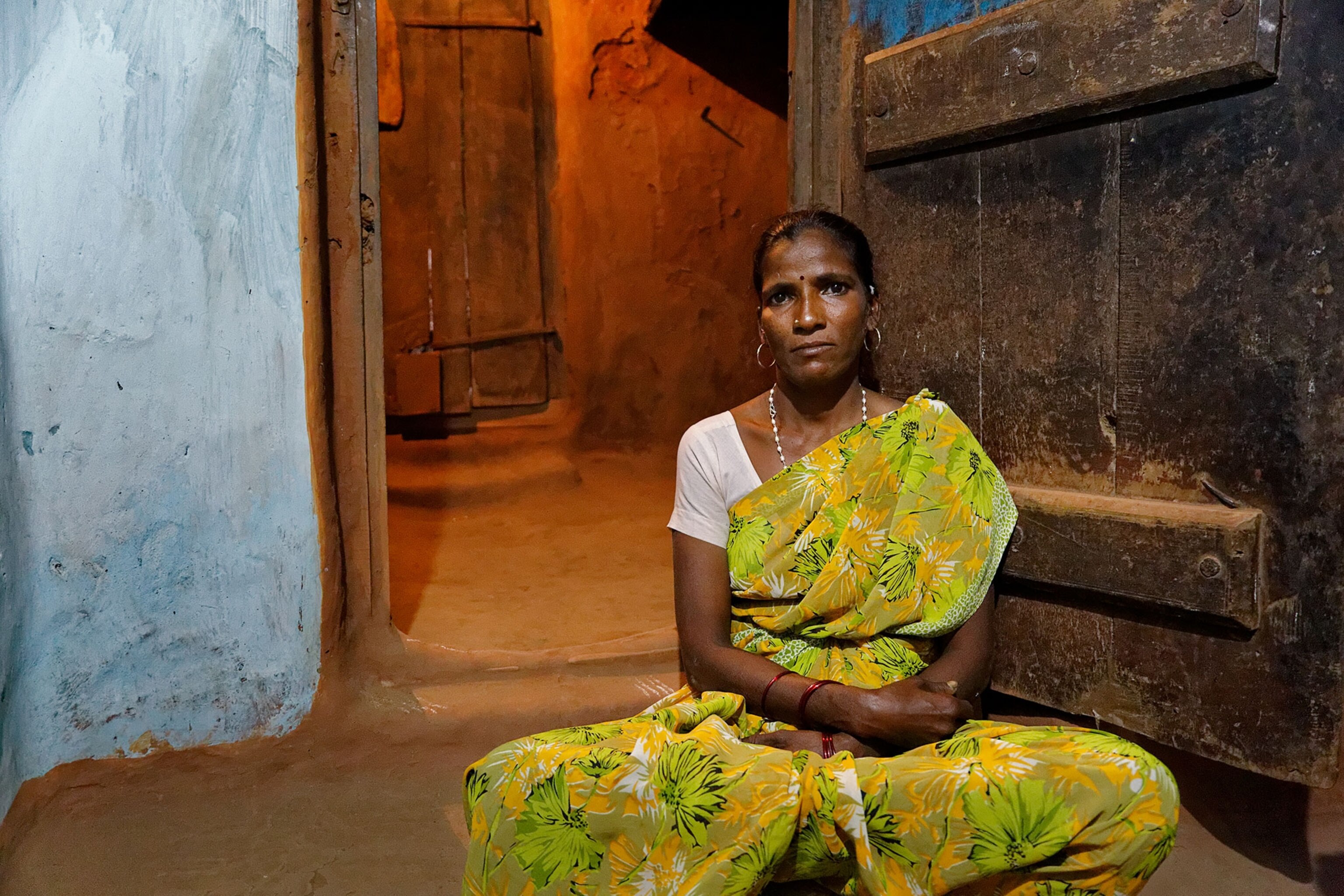 a woman sitting in a village in India