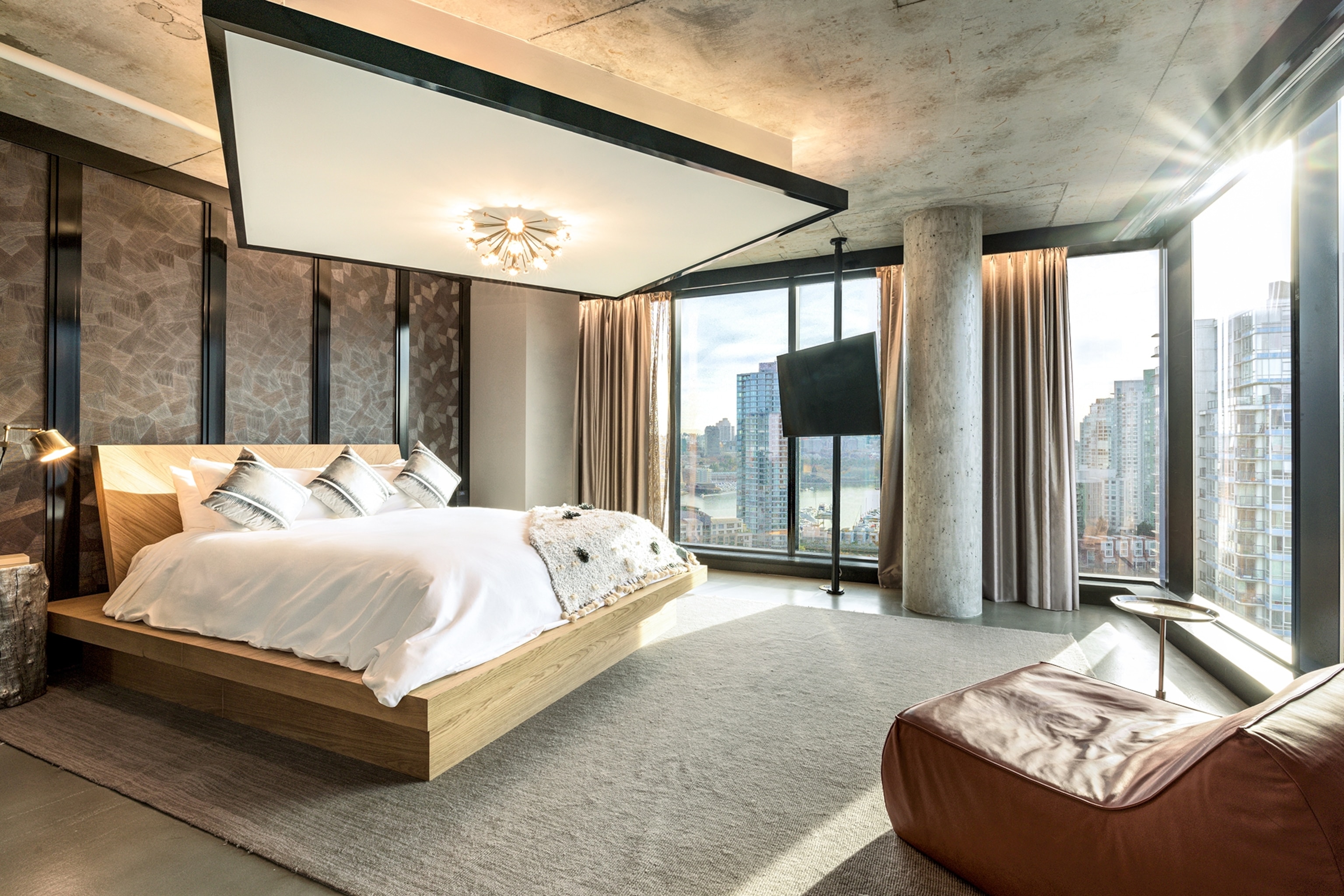 The spacious interiors of a hotel bedroom suit with a floating bed frame and panoramic view.