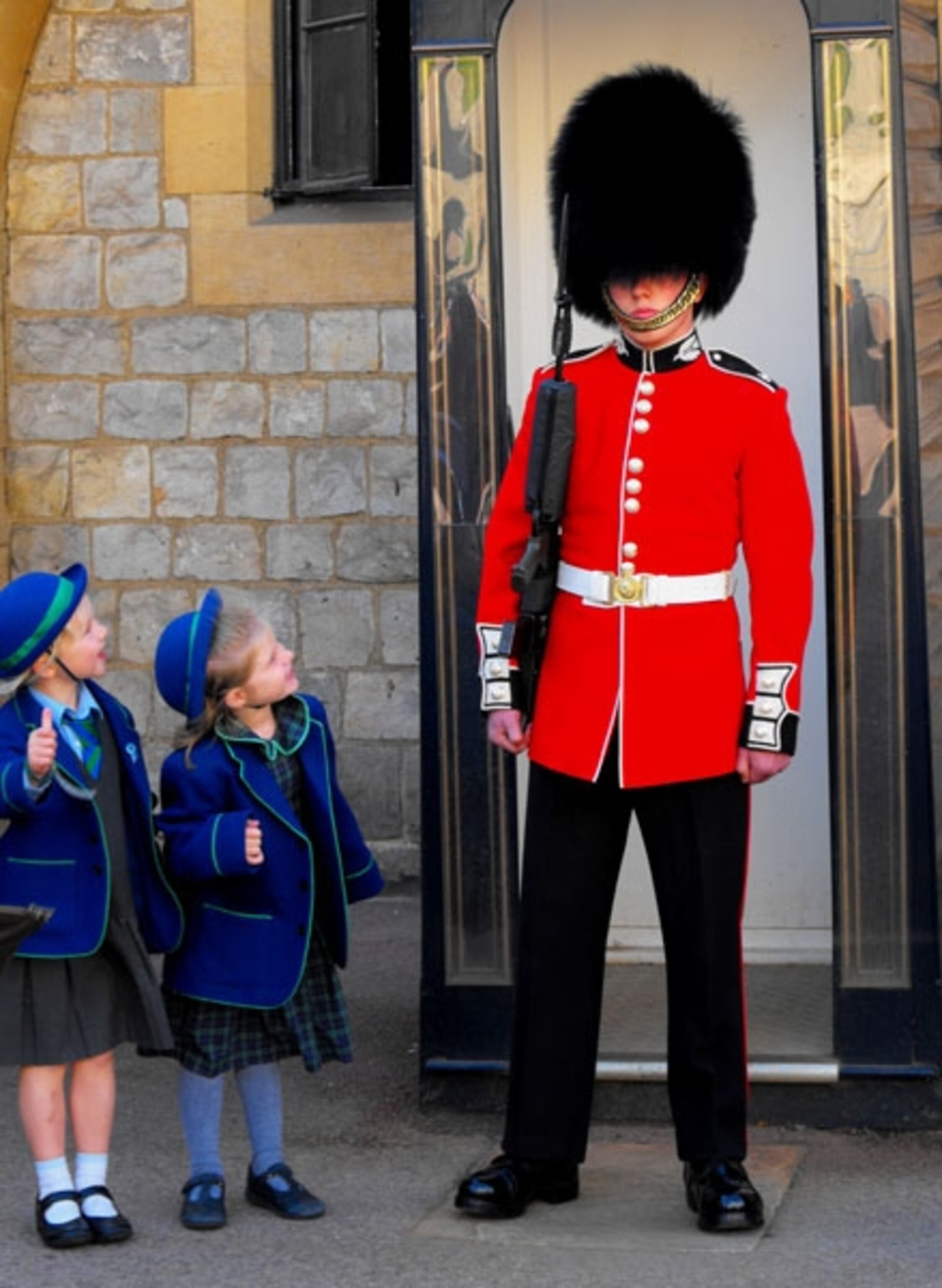 Two schoolgirls looking up at guard outside Windsor Castle