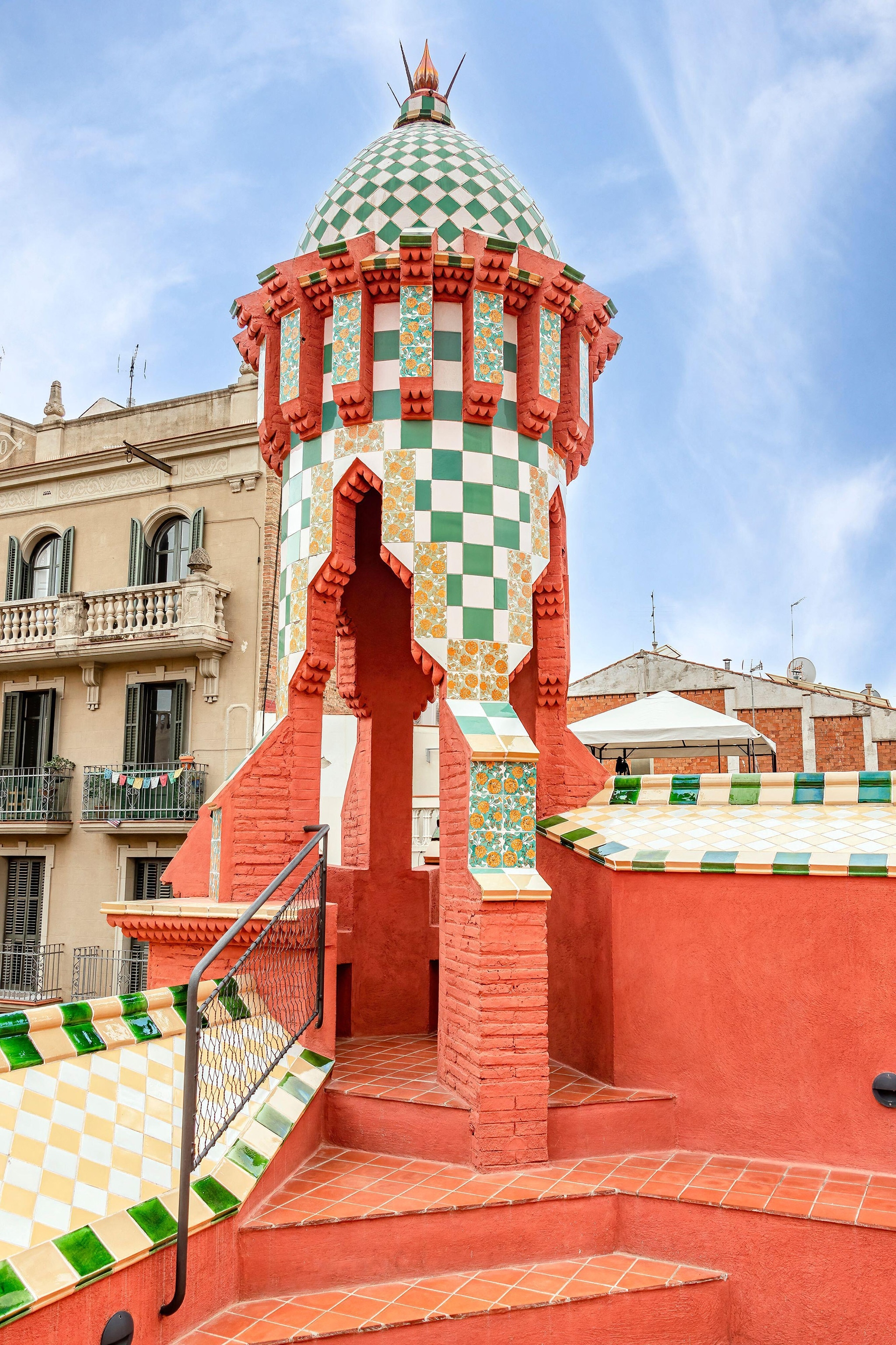 A turret painted in various colors and patterns, including green and white checkers and rust red.