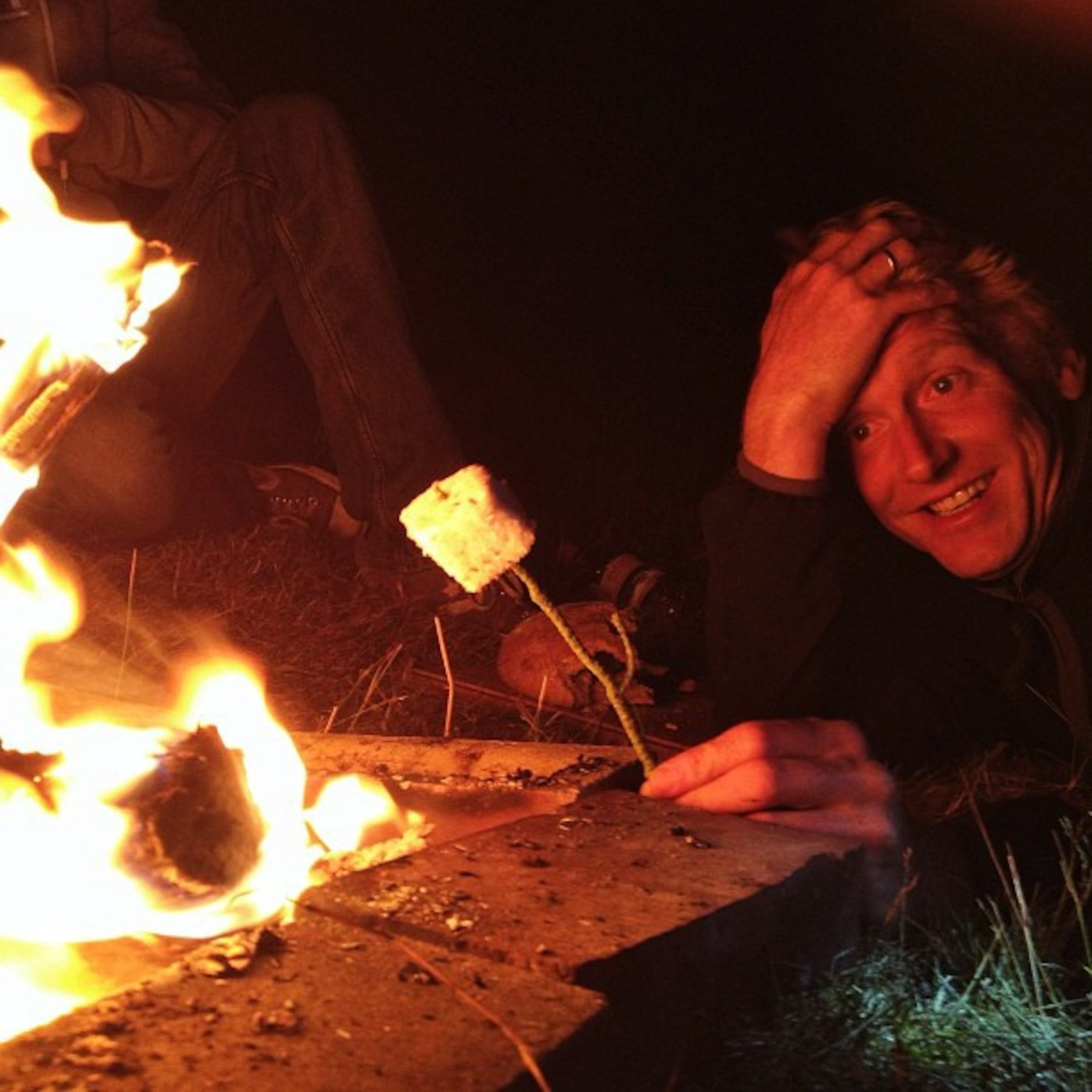 Alastair Humphreys toasting a marshmallow near a fire