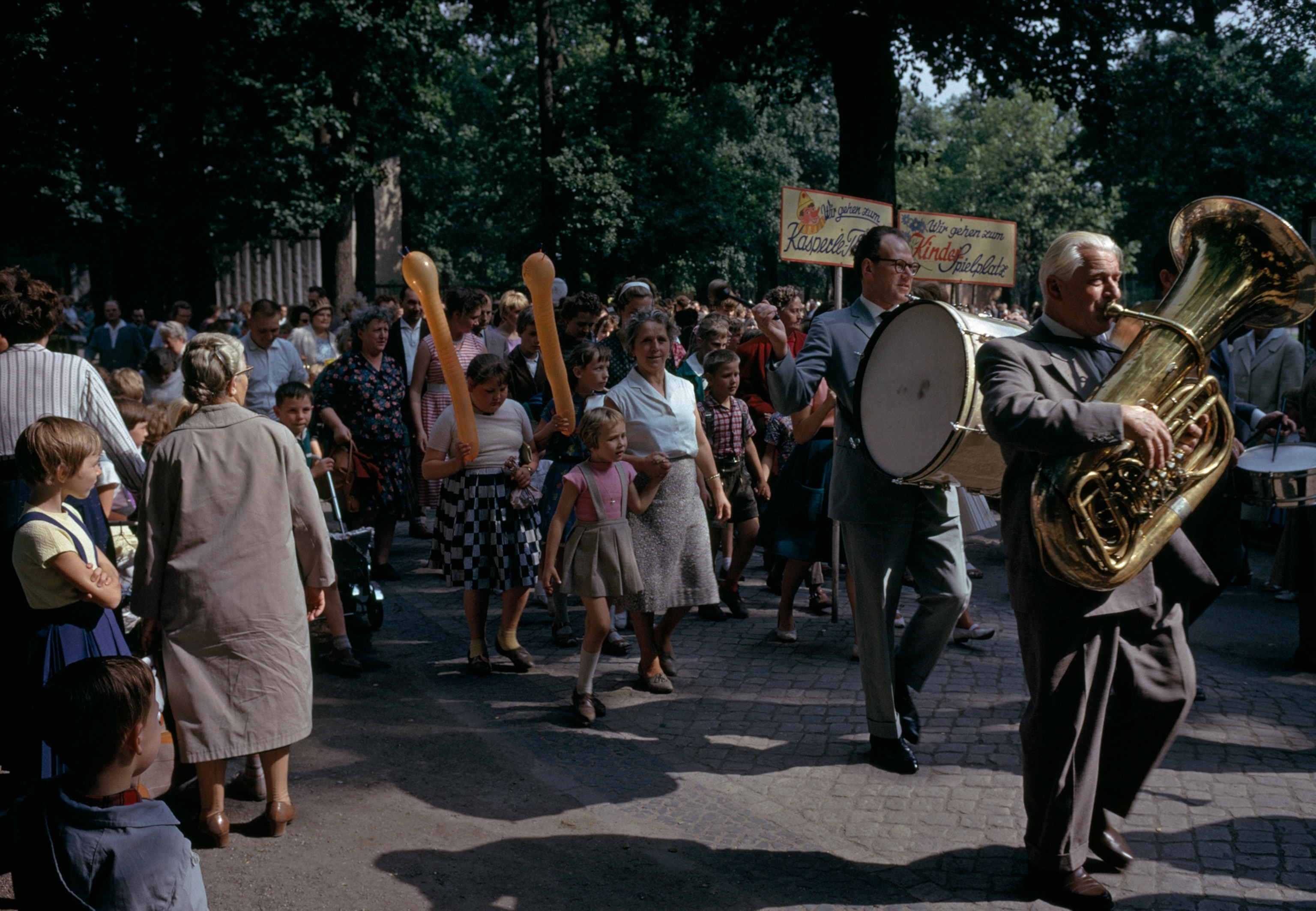 Tuba-tooing Pied Piper leads children to a playground in the zoo beside the Tiergarten. A public park for two centuries, the Tiergarten lost its trees in the bitter winter of 1945-46, when Berliners had to cut them for firewood and turn rose gardens into cabbage plots. Today a million new trees rooted in the battle-scarred soil make the park once again the city's "green heart." A sign proclaims, "We go to the children's playground."