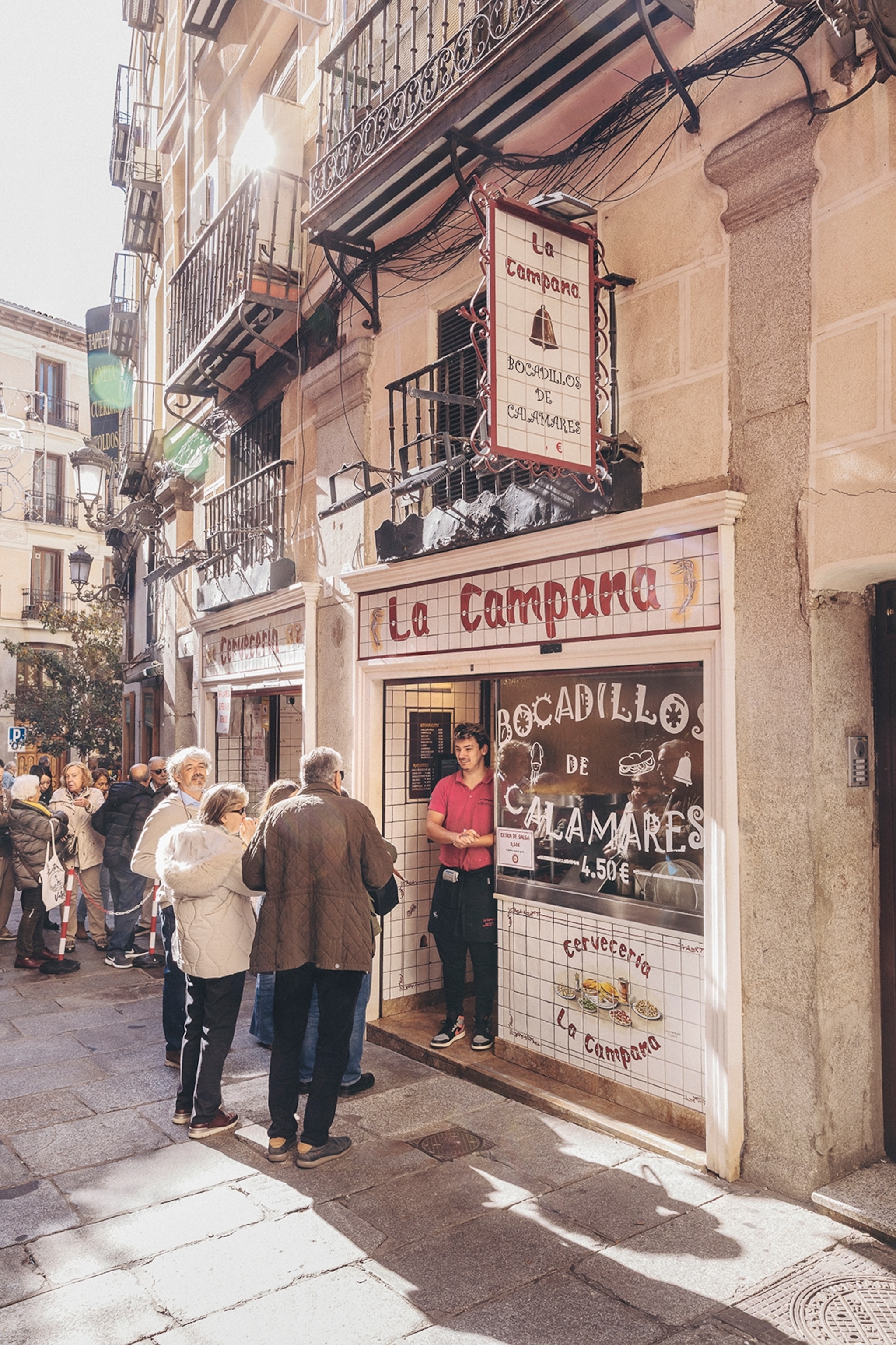 The shopfront of a sandwich place on a cobble-stoned street in Madrid.