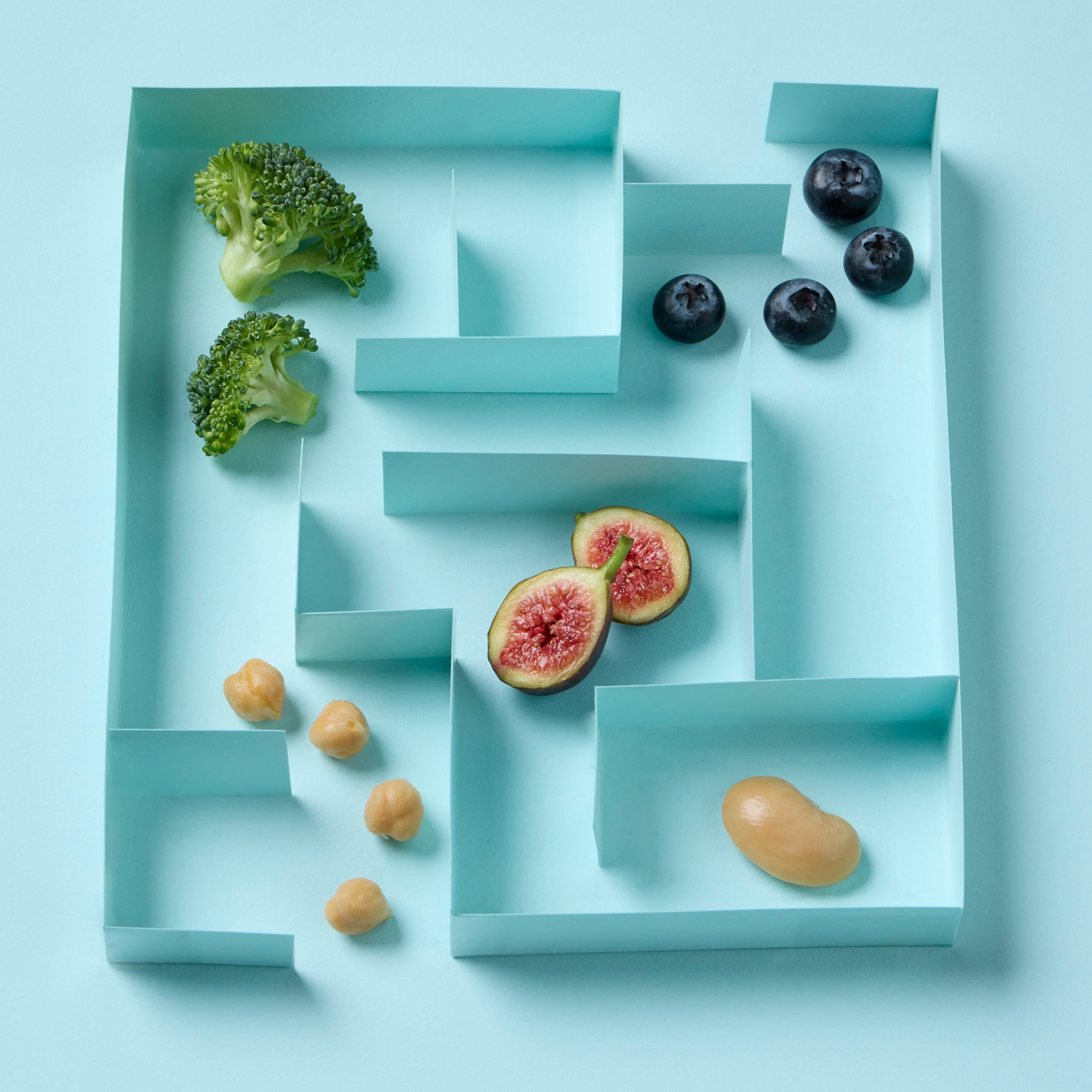 Various fruits and vegetables placed within a blue maze.