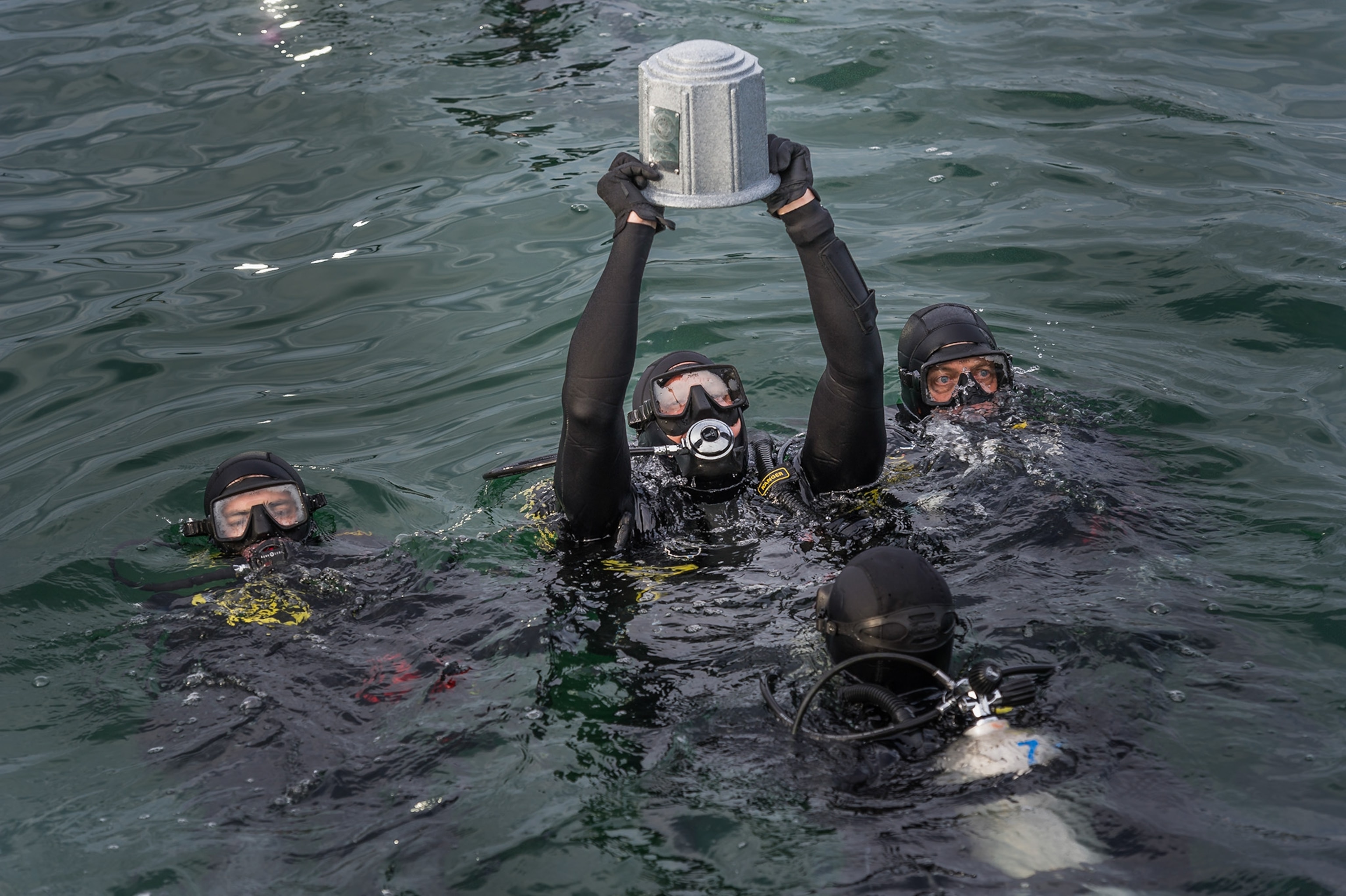 diver in water holding up urn