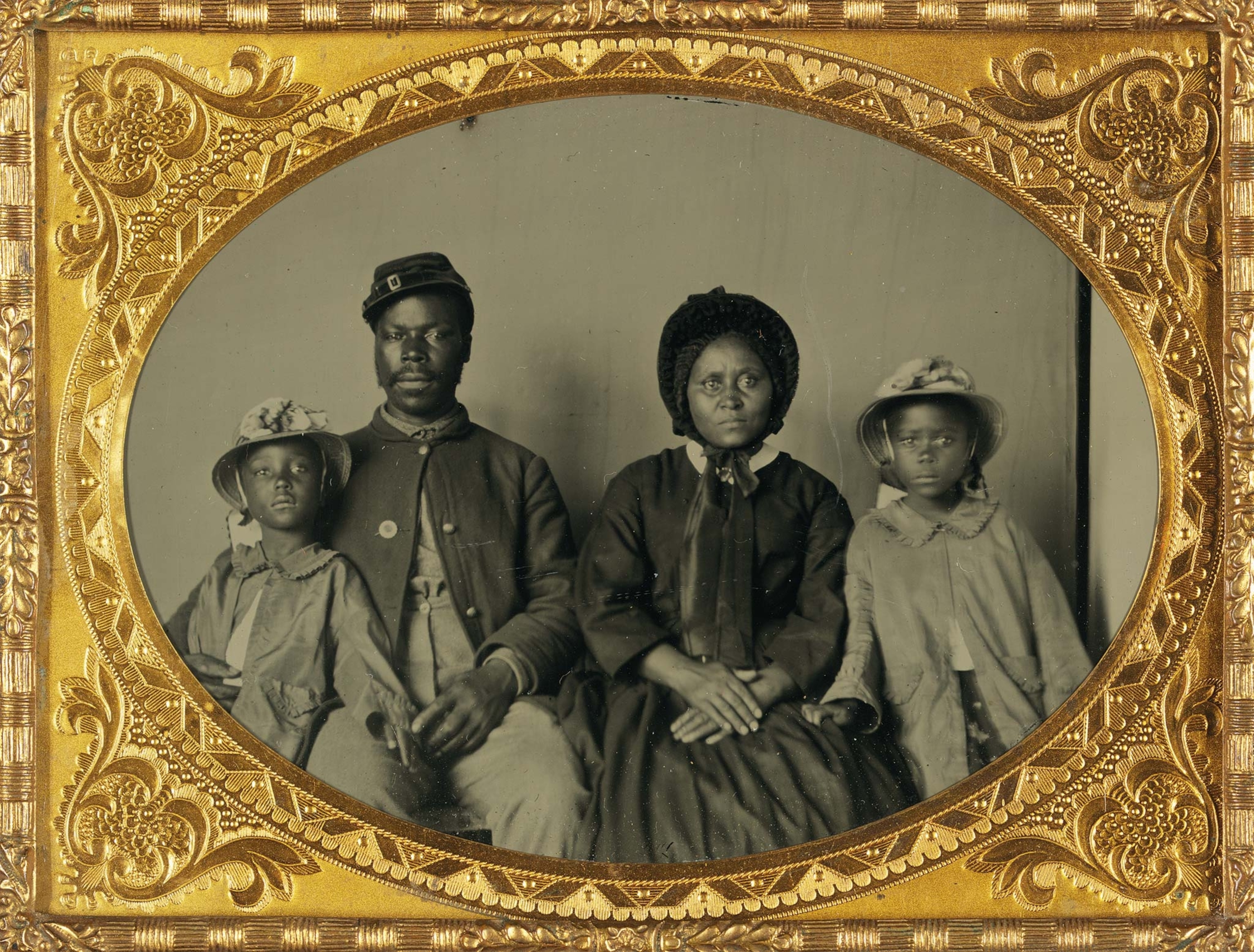 An unidentified soldier (possibly from a Maryland regiment) poses for a family portrait with his wife and daughters.
