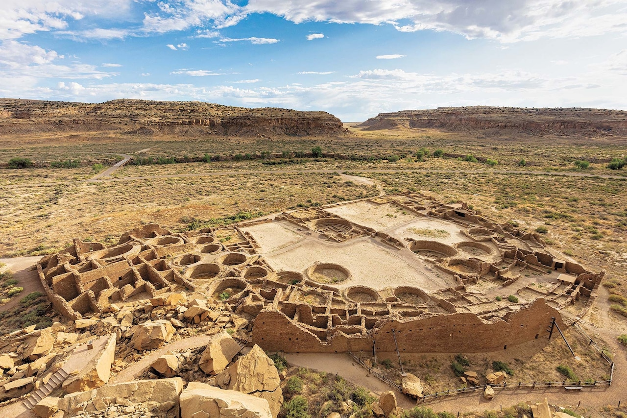 An aerial view of Chaco Canyon's ceremonial kivas, or chambers, with red rocks in the distance