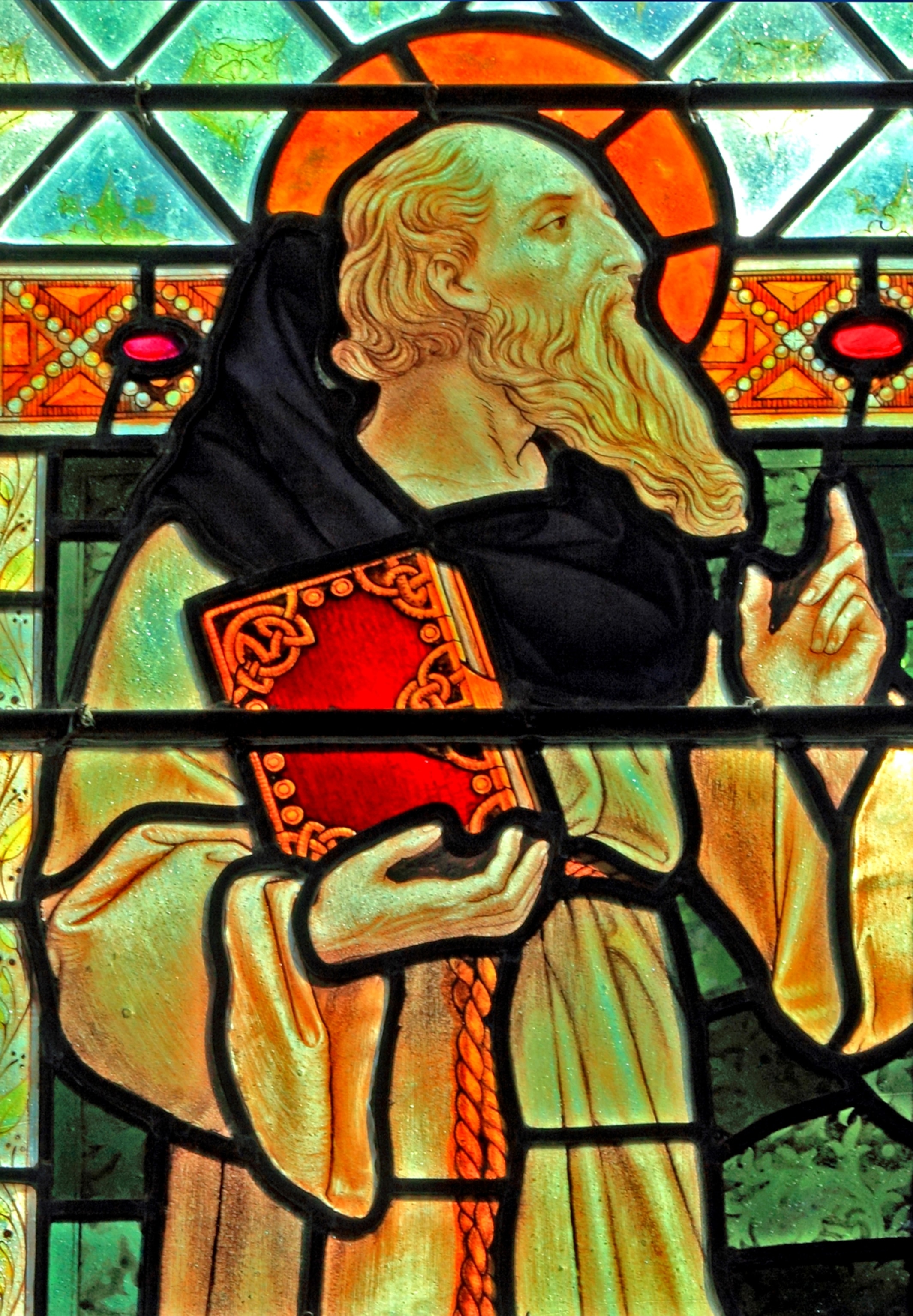 A stainglass of a man with a book.