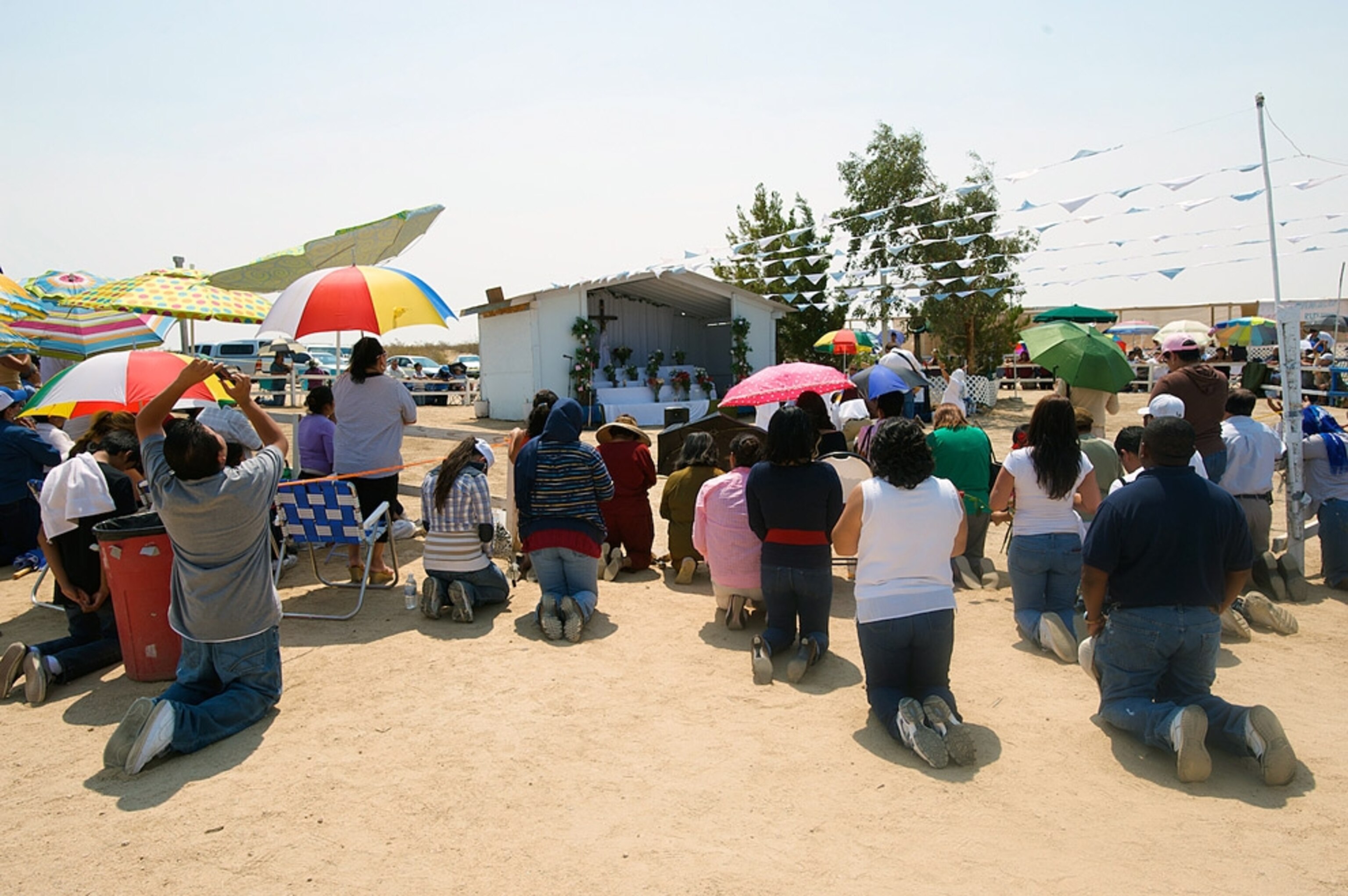 A crowd kneeling outside an altar