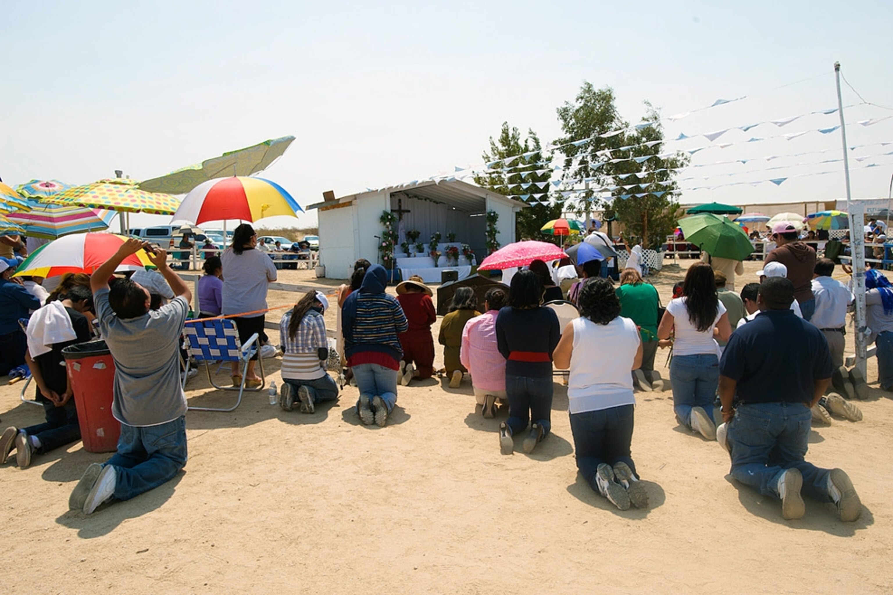 A crowd kneeling outside an altar