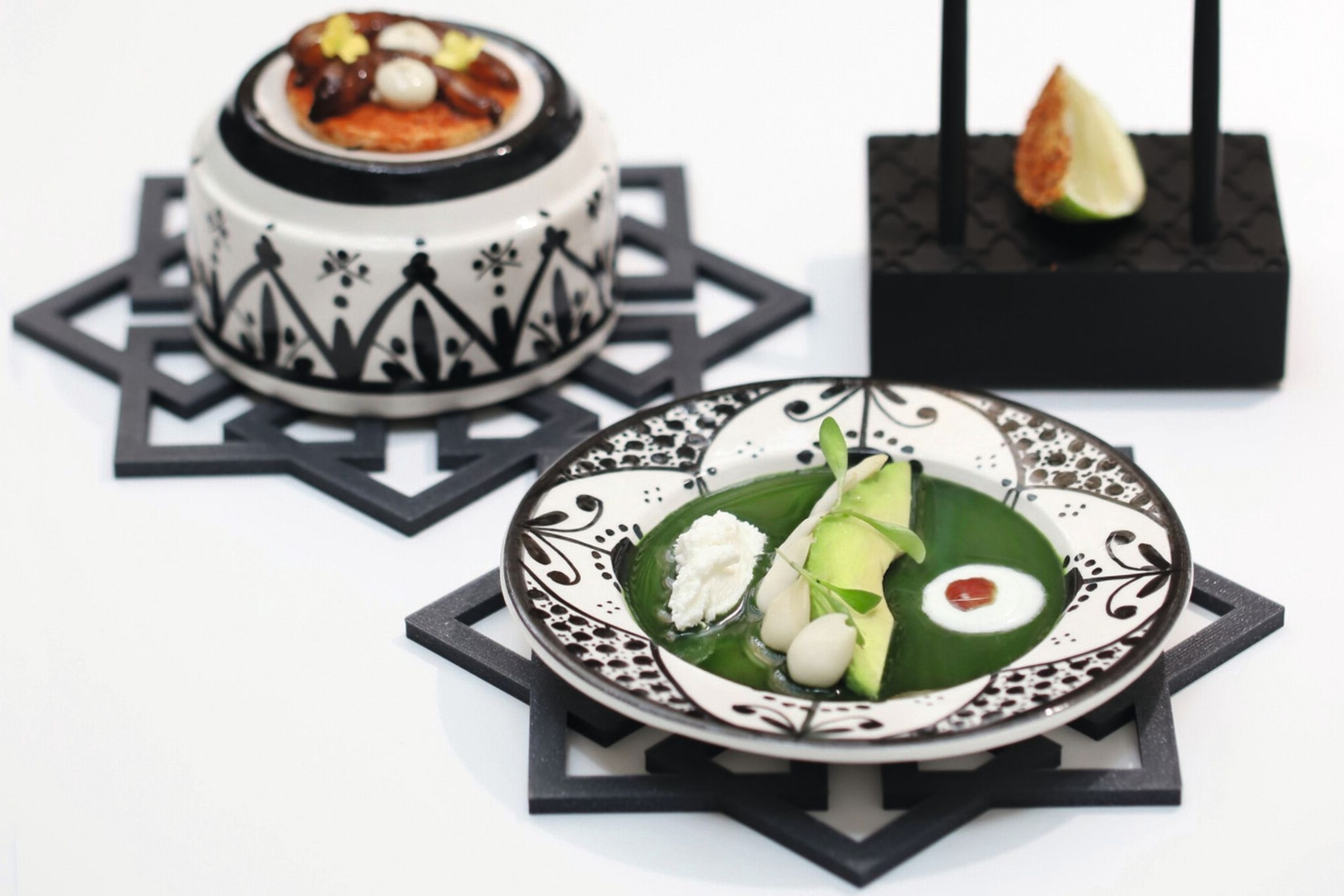 Avocado in spinach jelly with yoghurt and pumpkin seeds accompanied by white prawn in carob and cascabel chili.