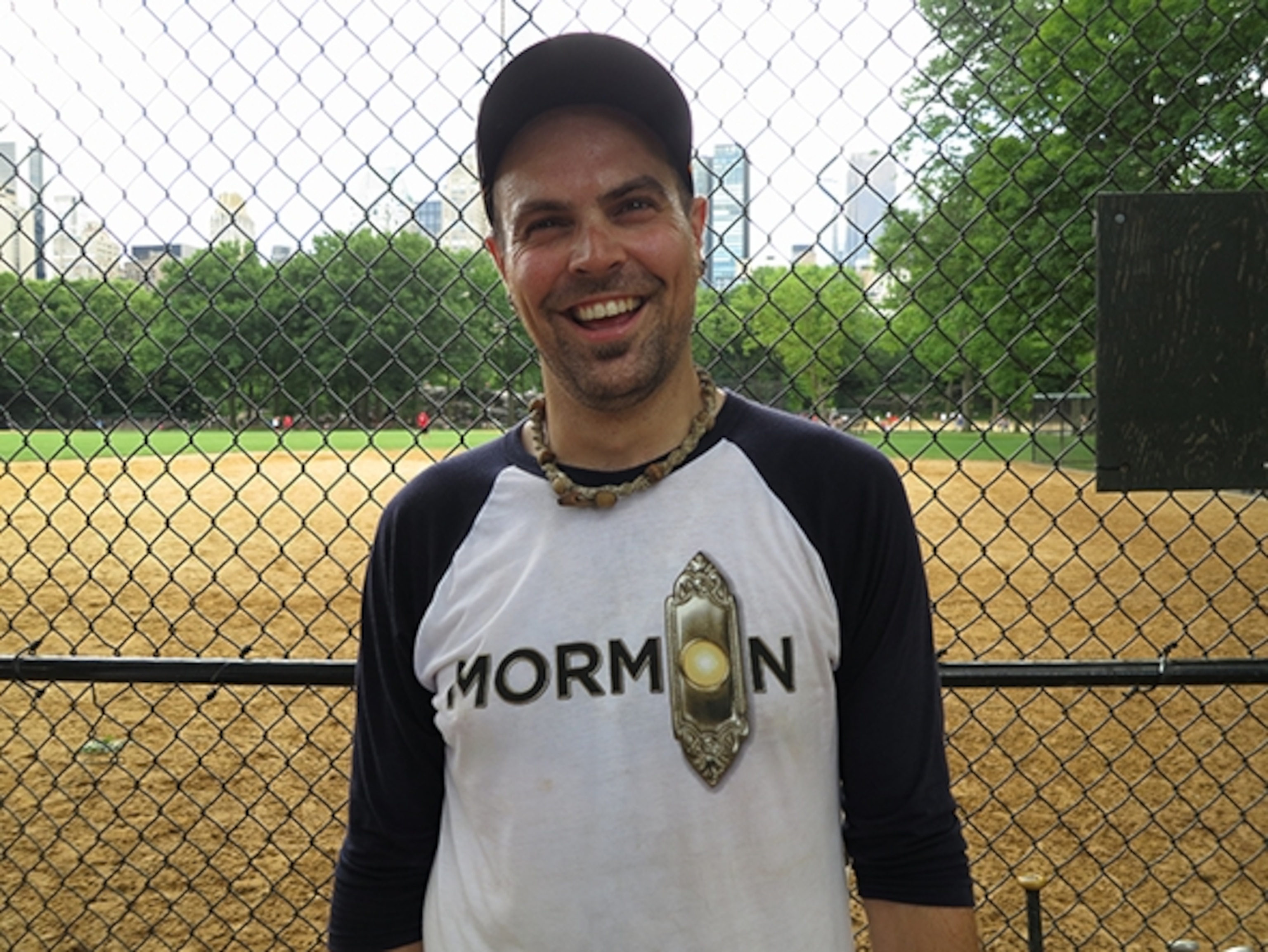 A ball player for The Book of Mormon poses for the camera in front of Heckscher Fields. (Photograph by Robert Reid)