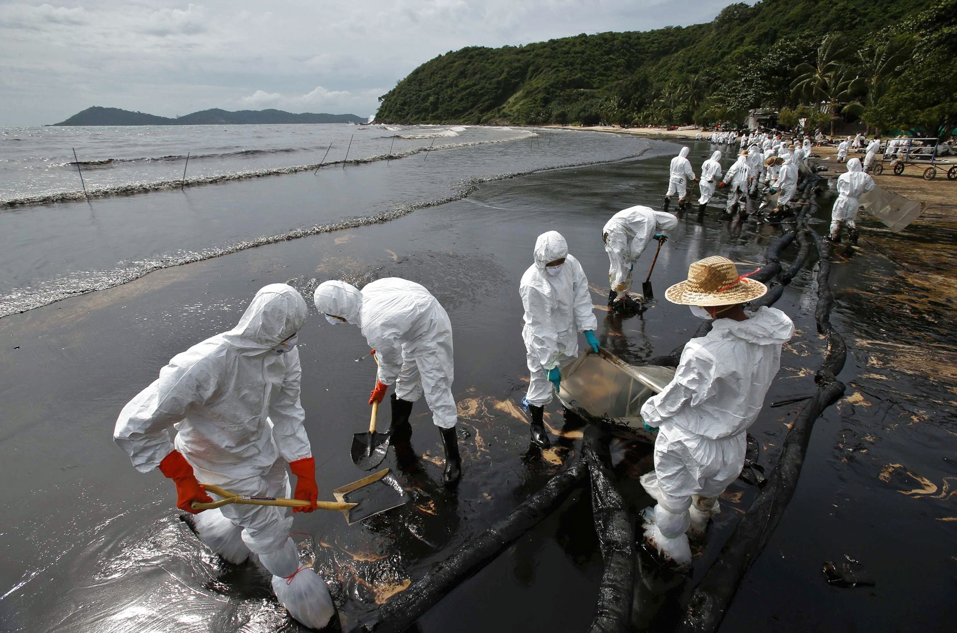 Cleanup crews work along Ao Prao Beach after a crude oil spill in the Gulf of Thailand.