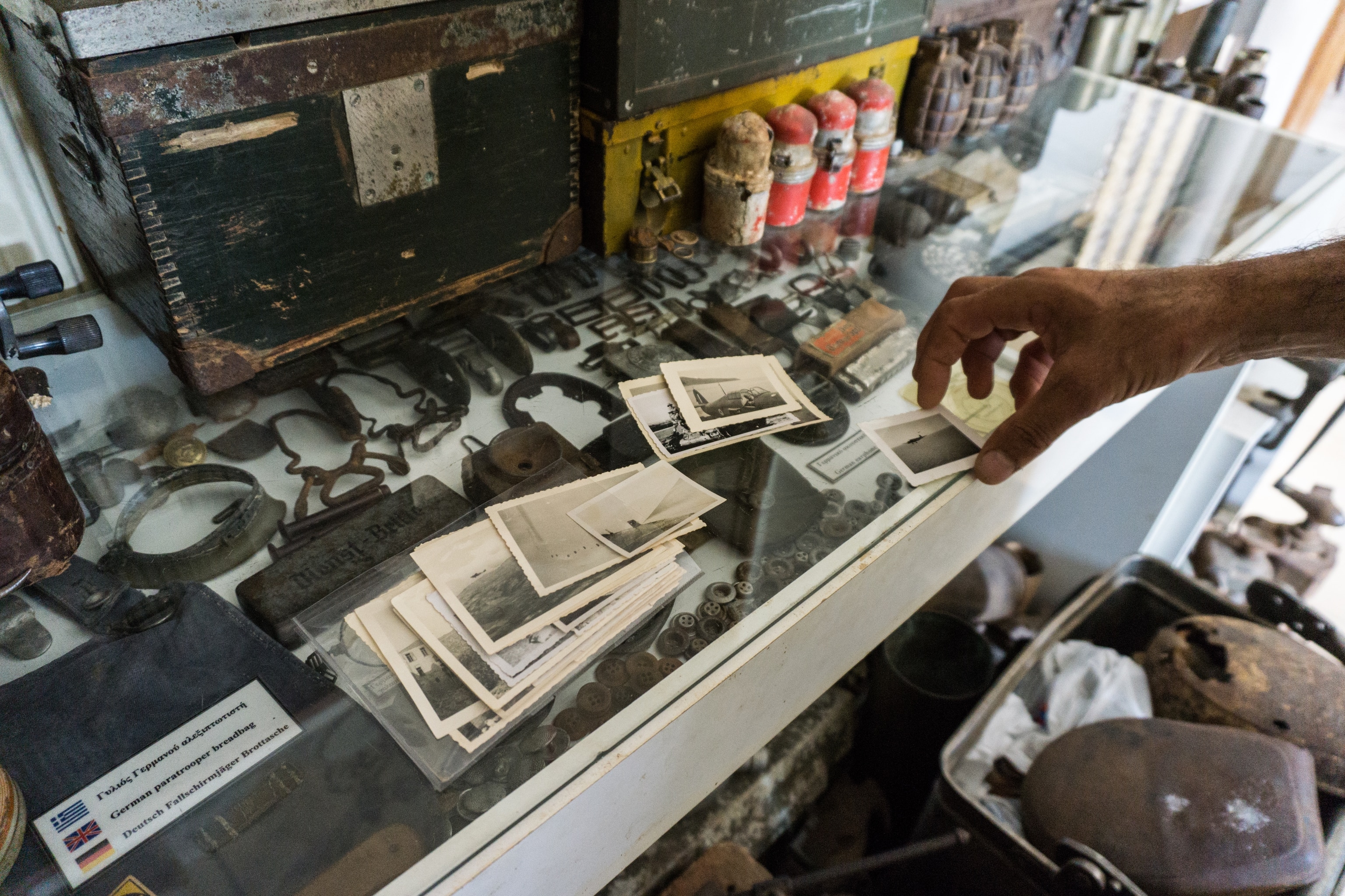 A case with various old photographs on it. Inside the clear case are different artifacts such as buttons and buckles.