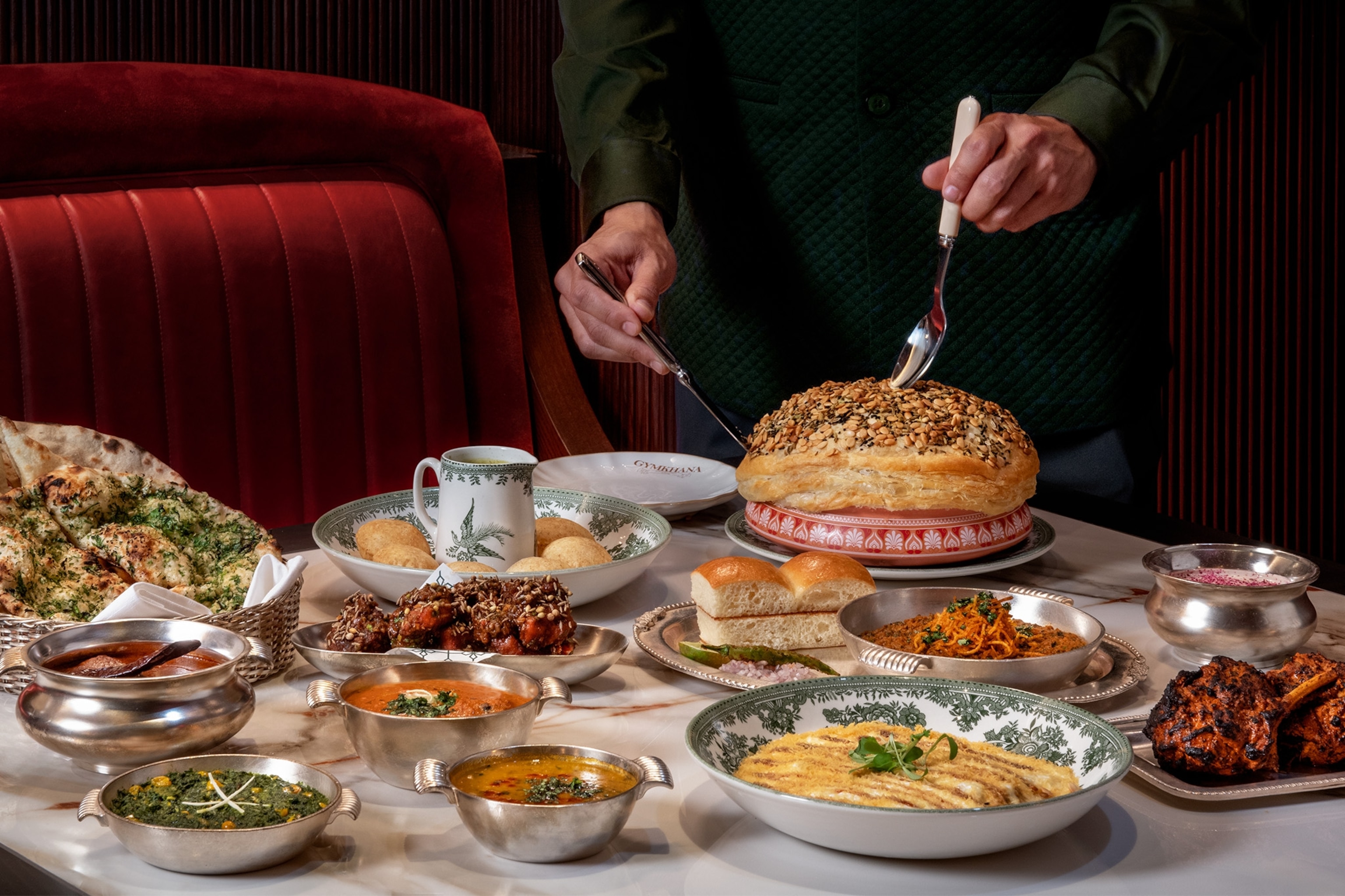 A table of vibrant Indian currys, breads and appetisers