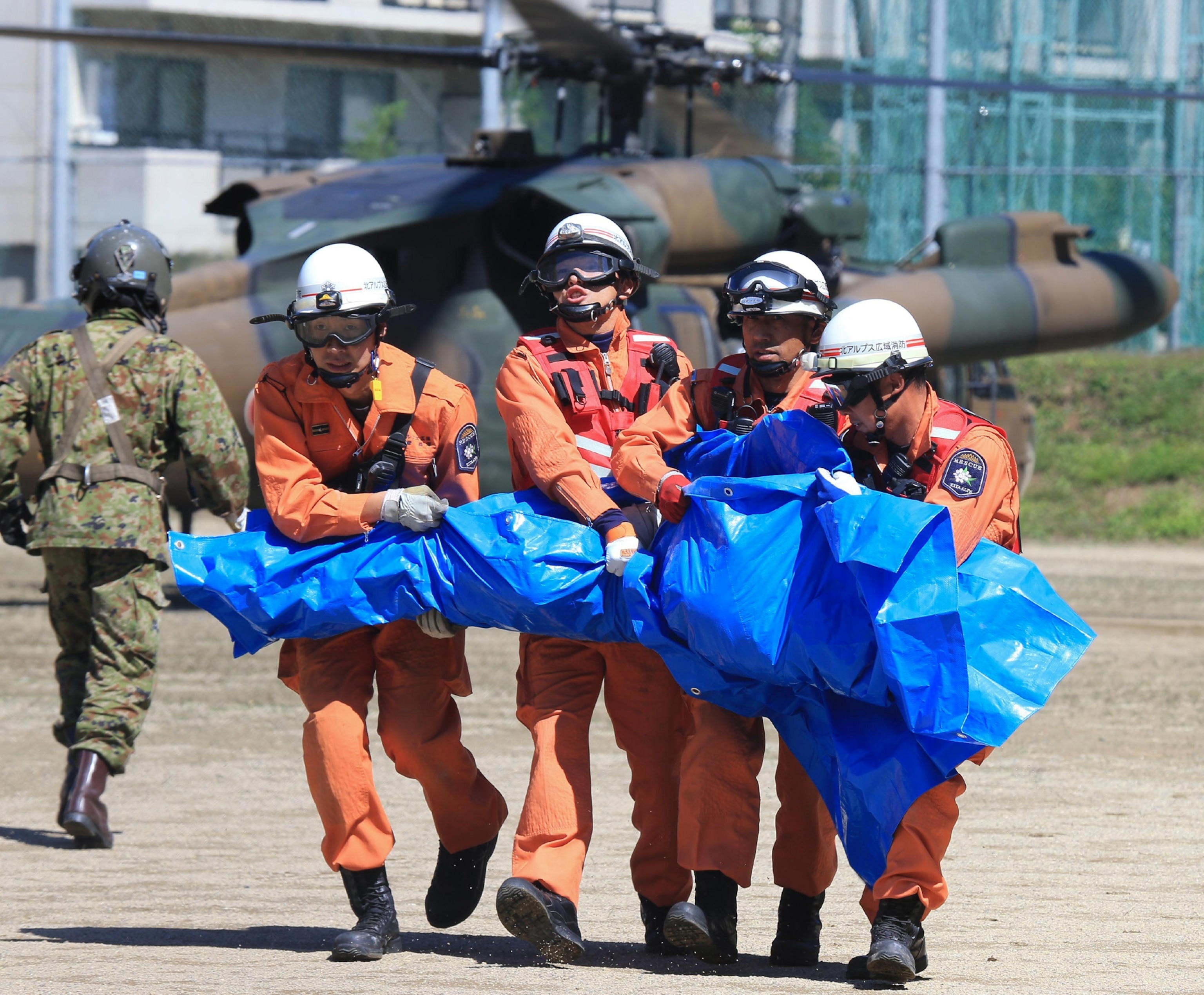 a body being transported by firefighters after the Mt. Ontake eruption.