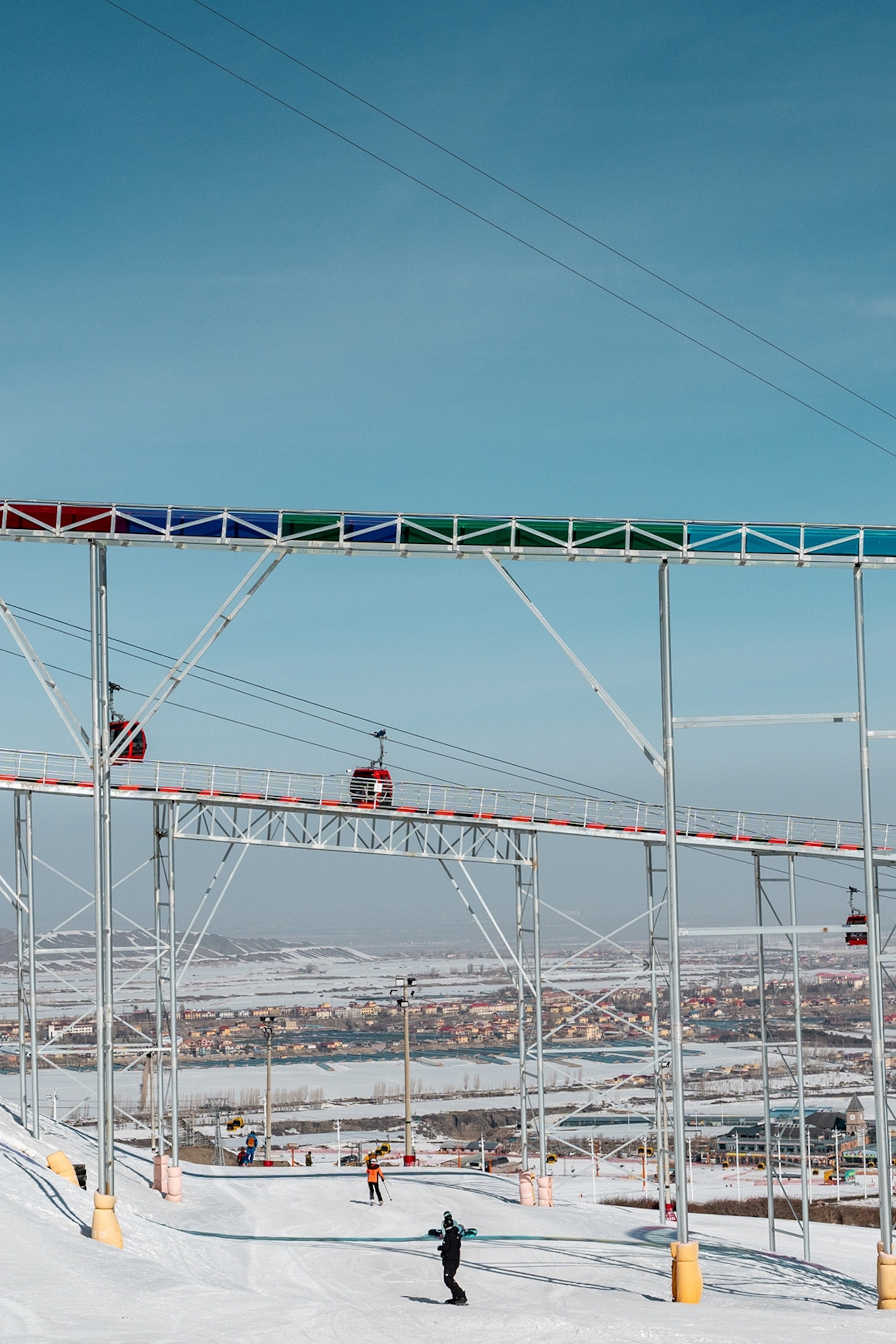 A network of ski lifts and tracks in a snowy mountain scene.