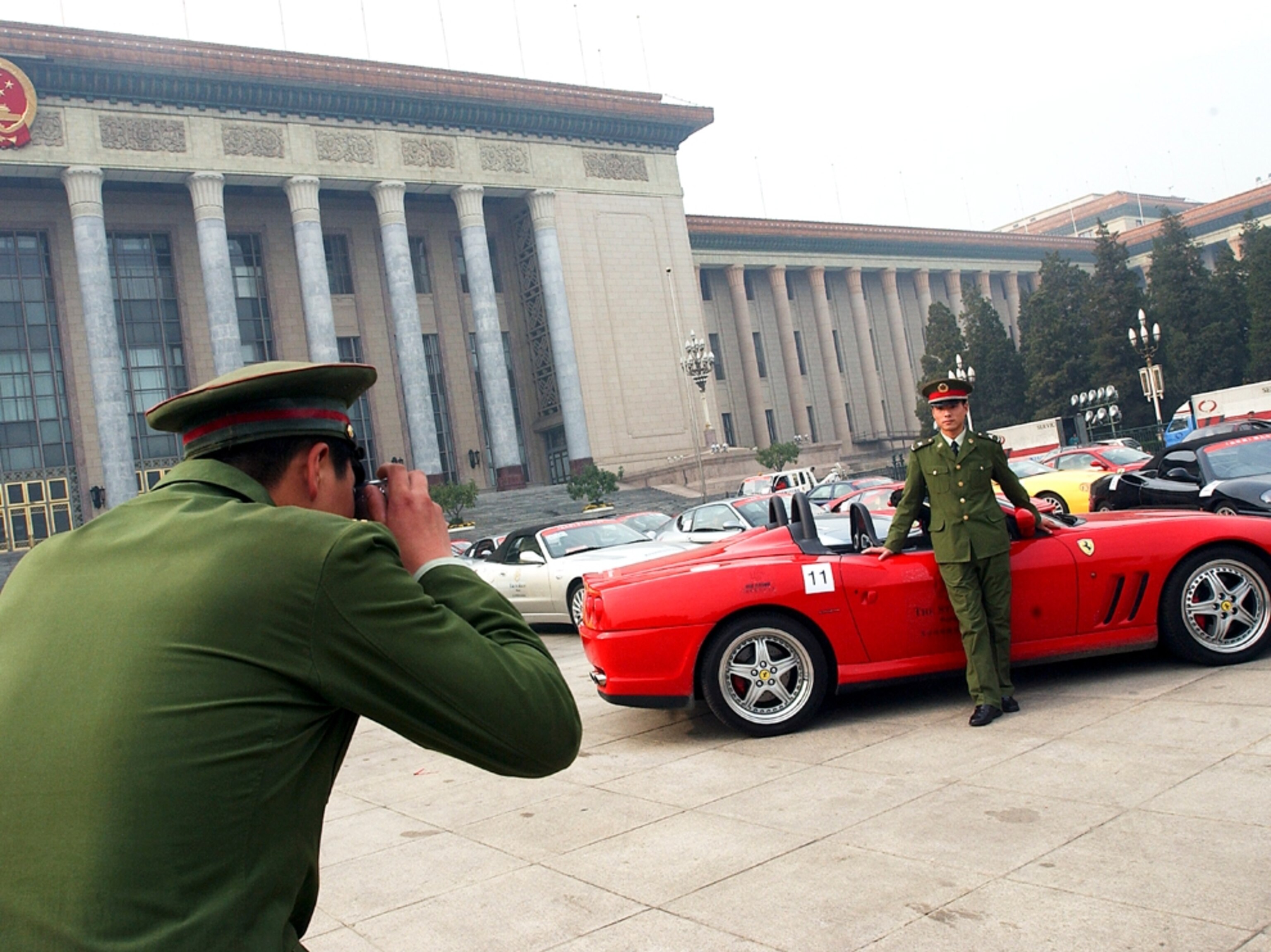 Chinese soldiers pose in front of Ferrarris, China