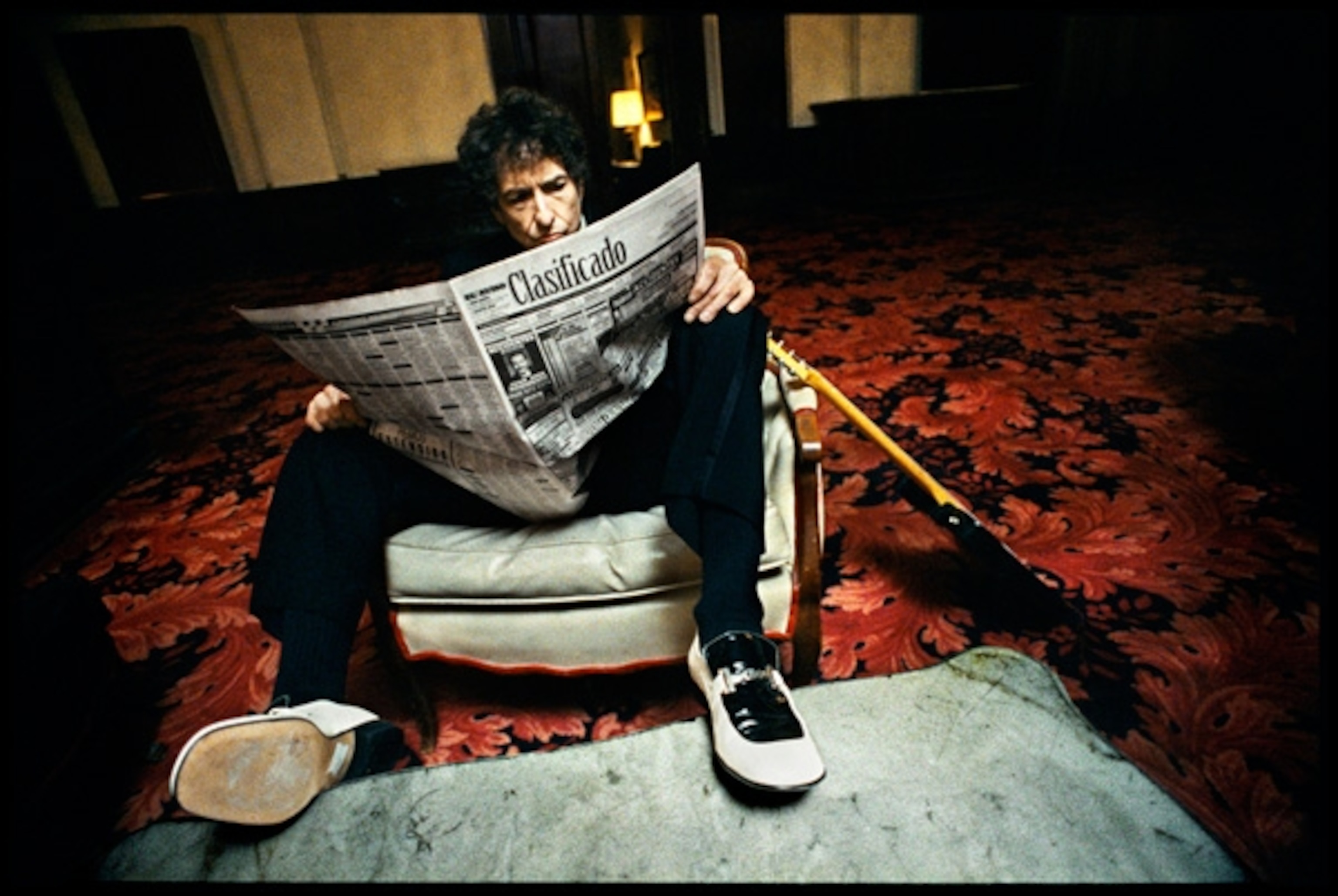Musician Bob Dylan reading a newspaper