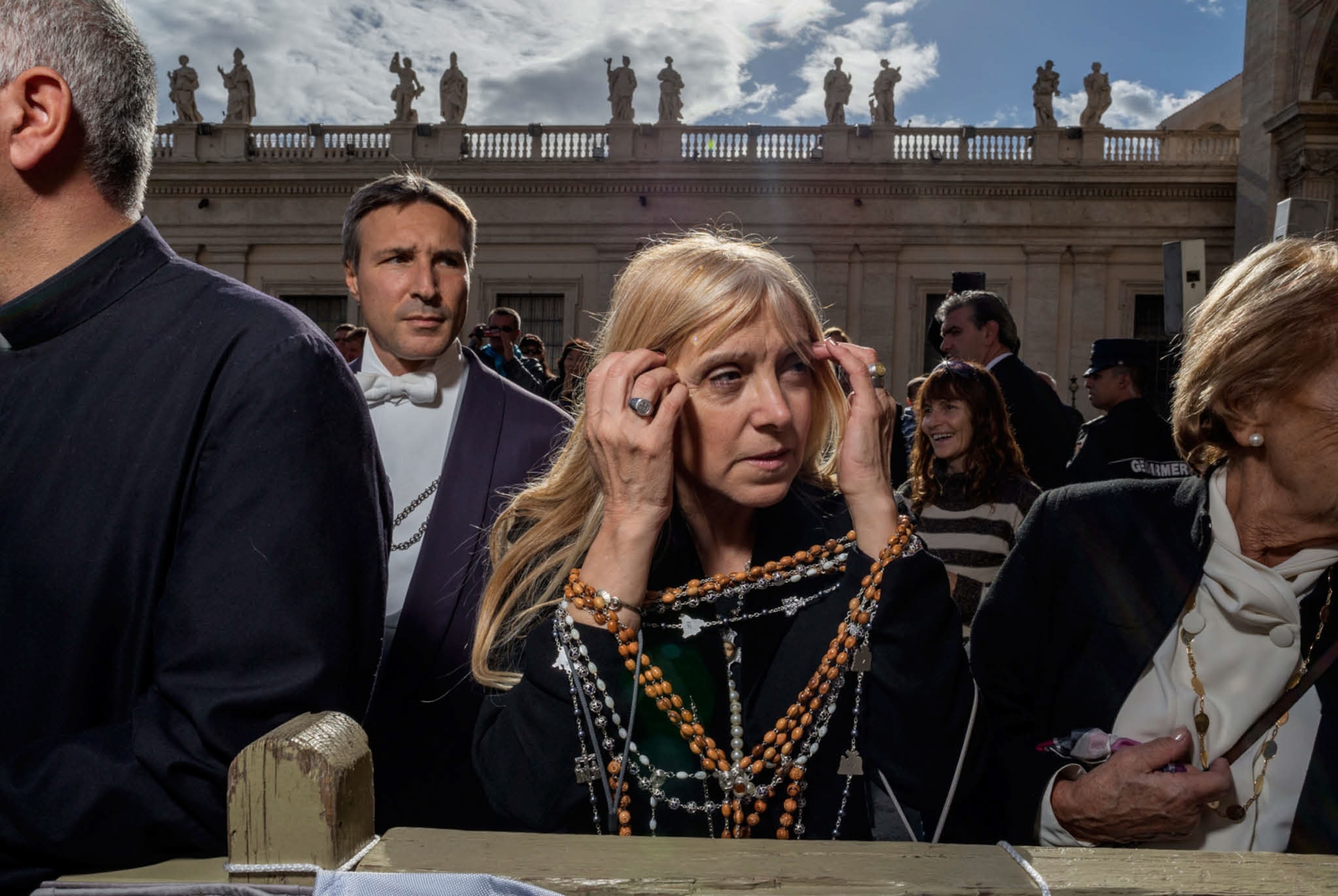 a woman waiting for Pope Francis holding a rosary