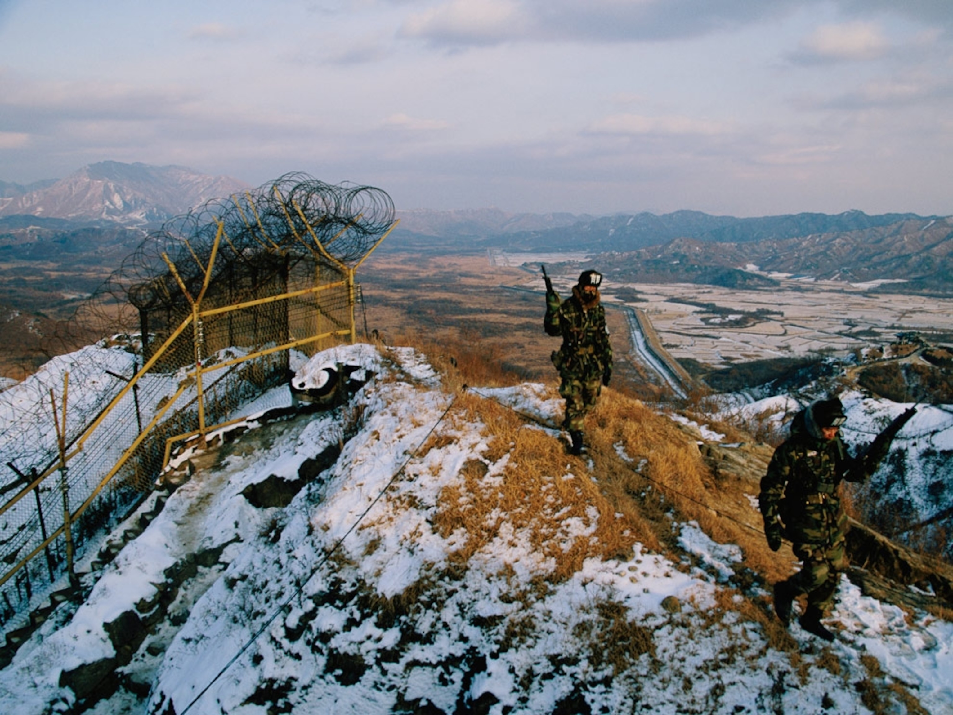 Soldiers patrolling a snowy ridge along the DMZ