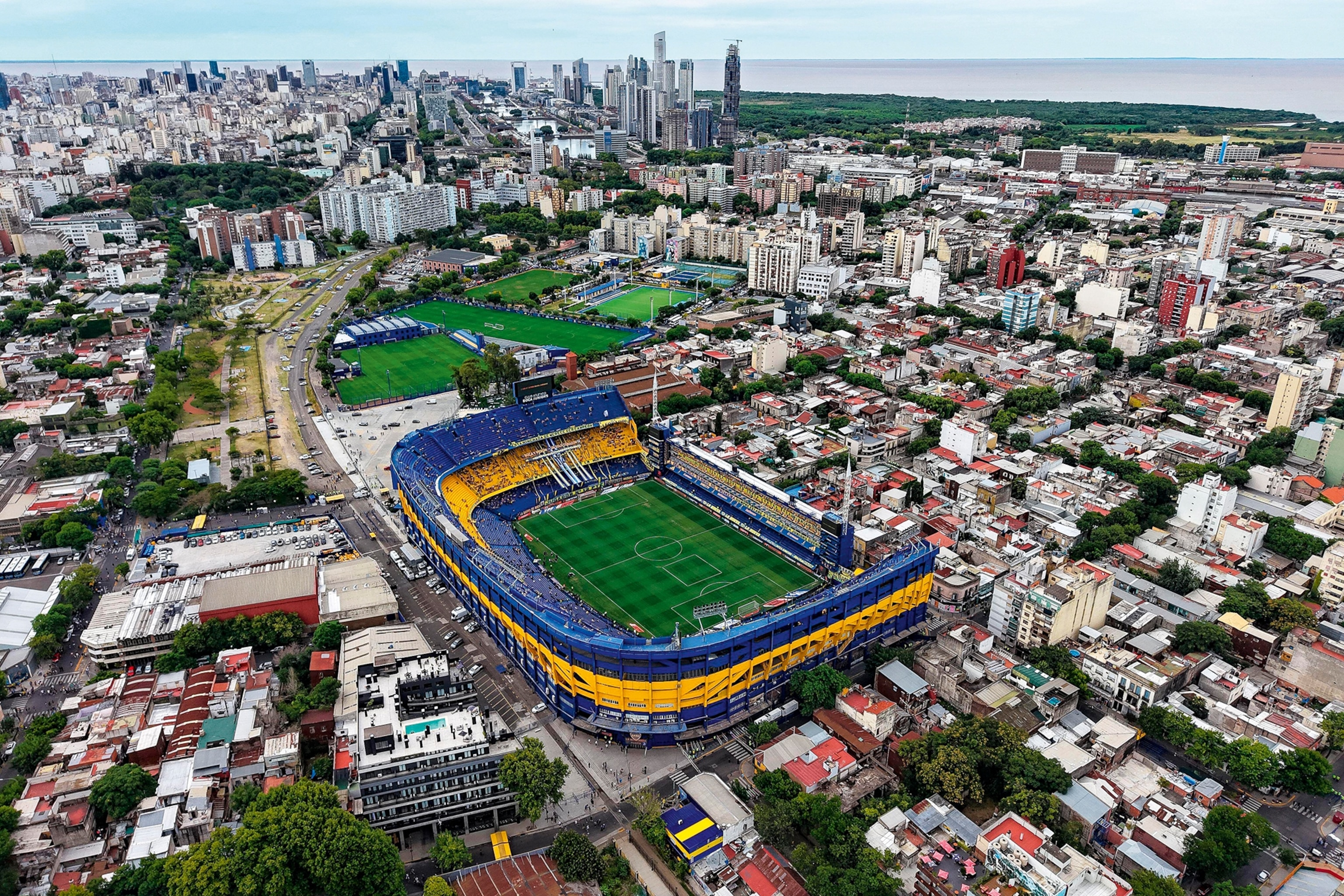 A birds-eye perspective on a rectangular football stadium in the middle of a densely populated city.