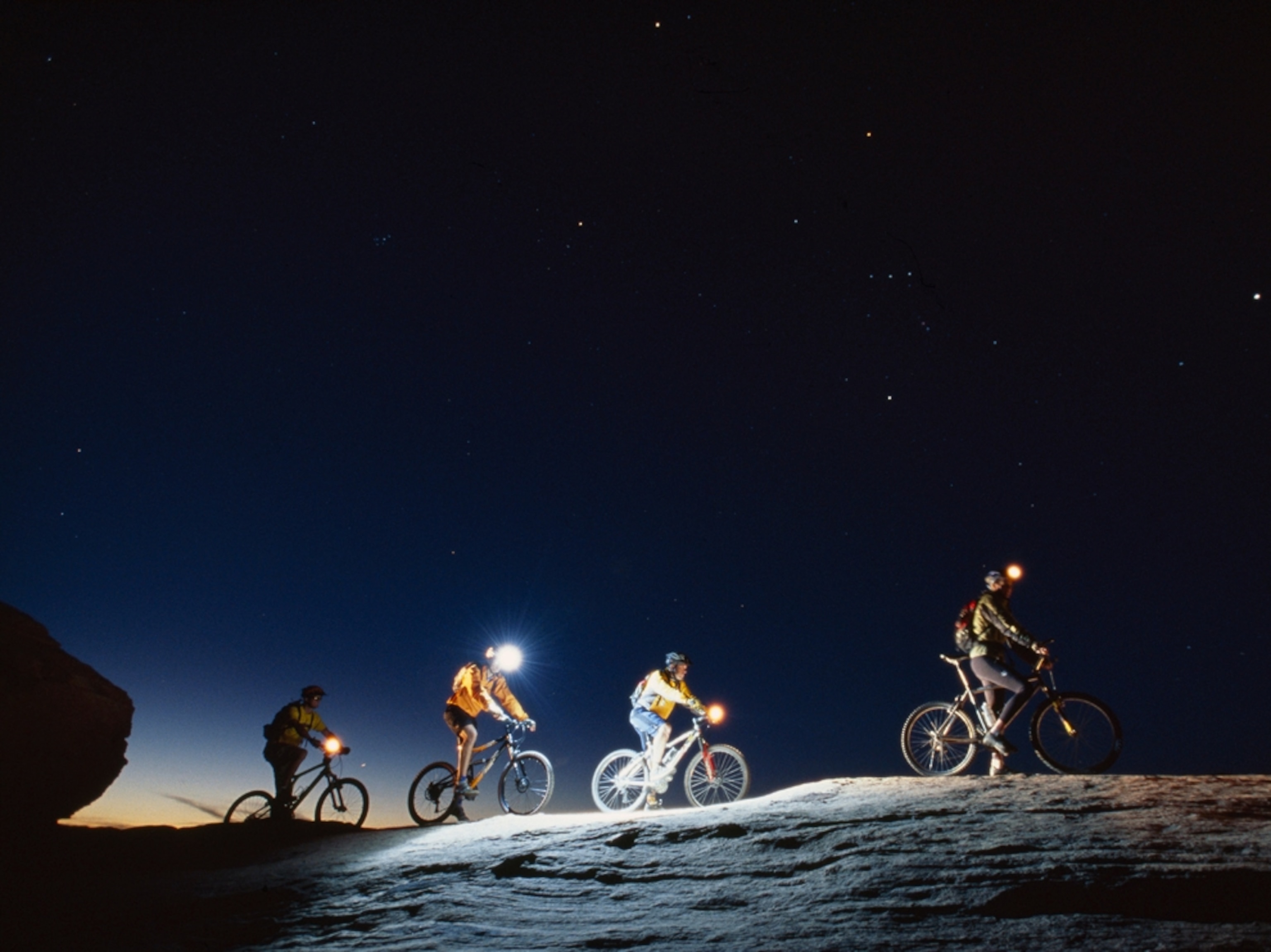 mountain bikers finishing up the 'slickrock trail' at dusk.
