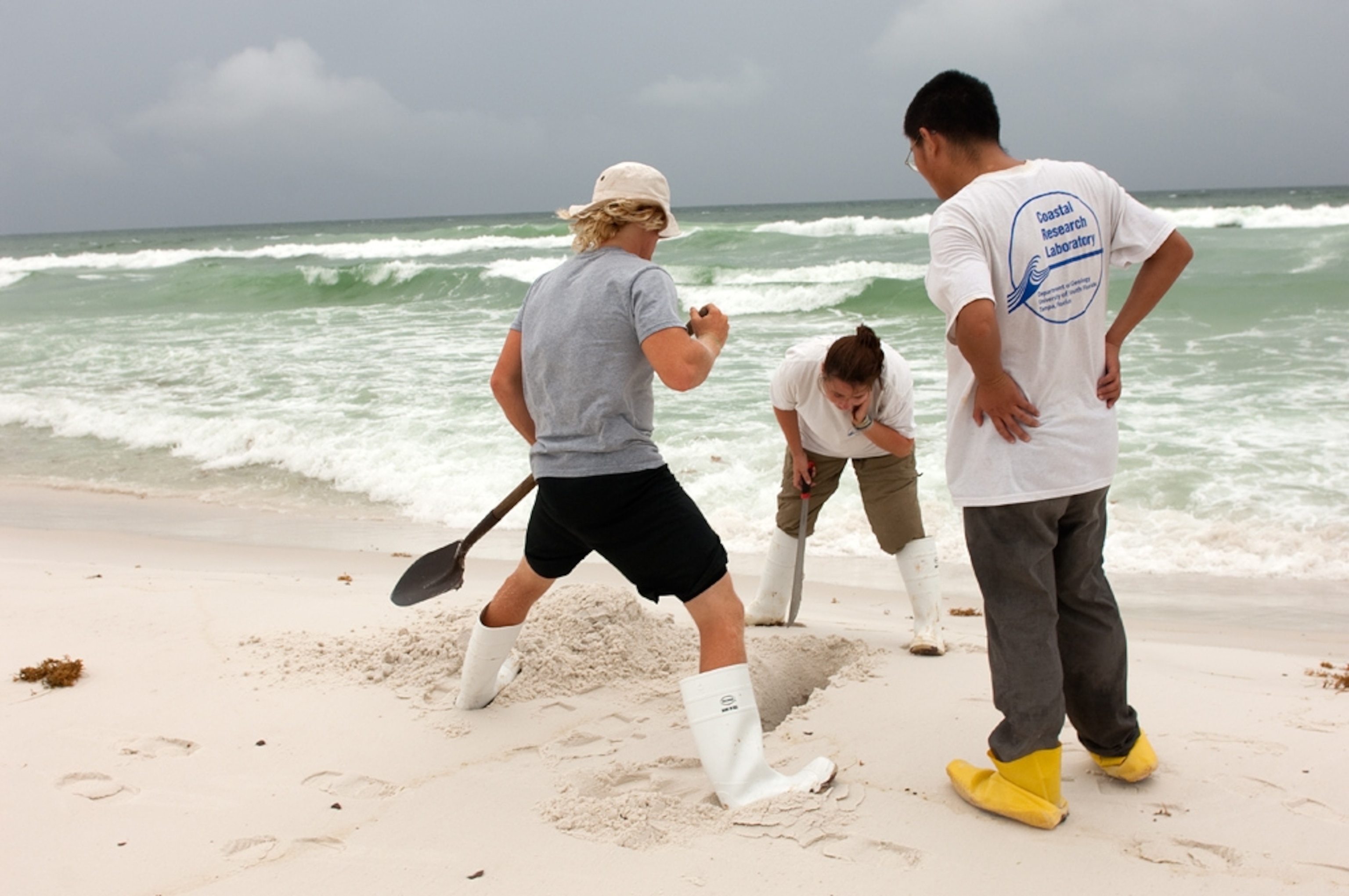A picture of geologists digging into a beach