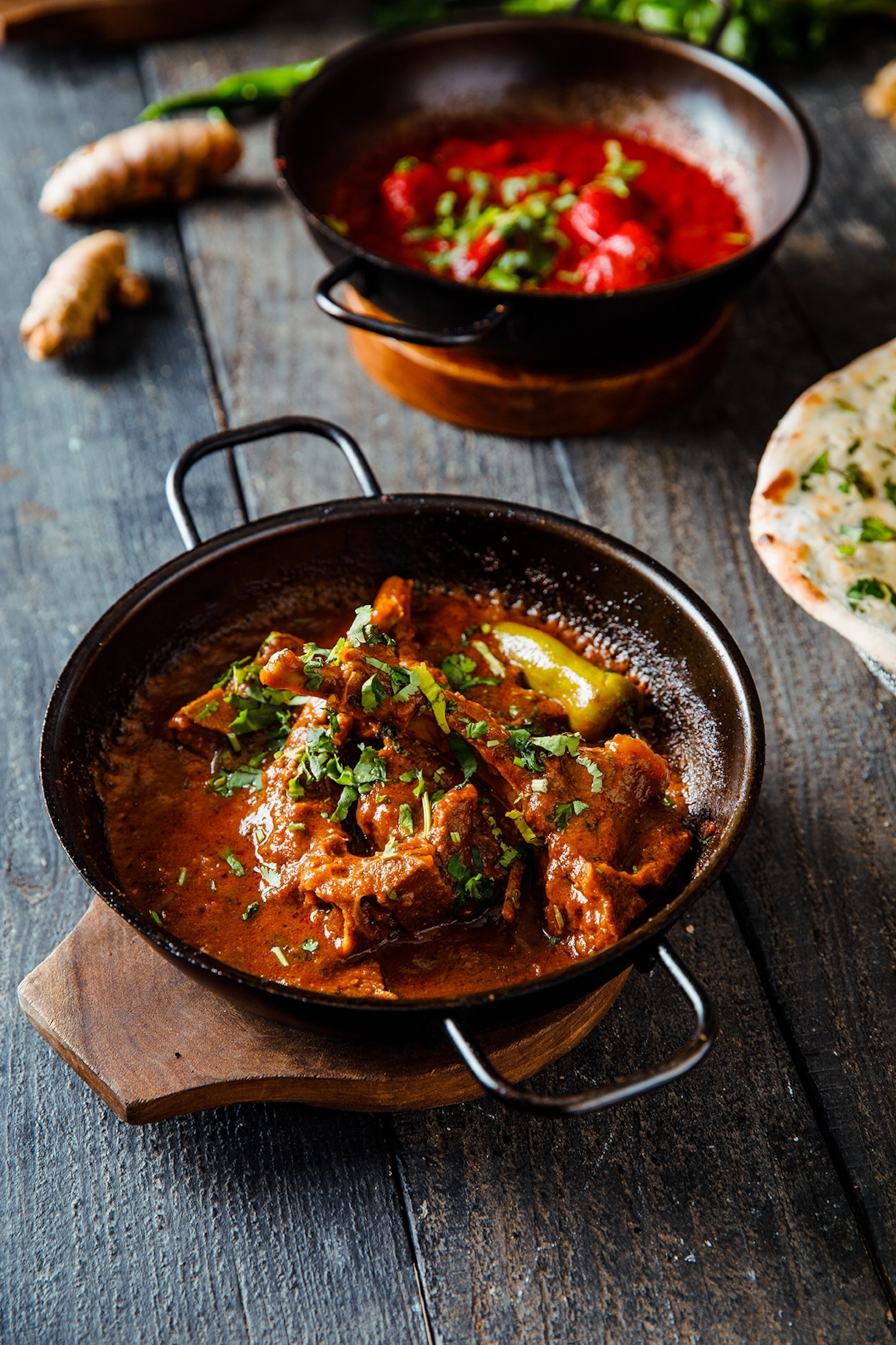 A flatlay of multiple metal vessels with south asian curries in them