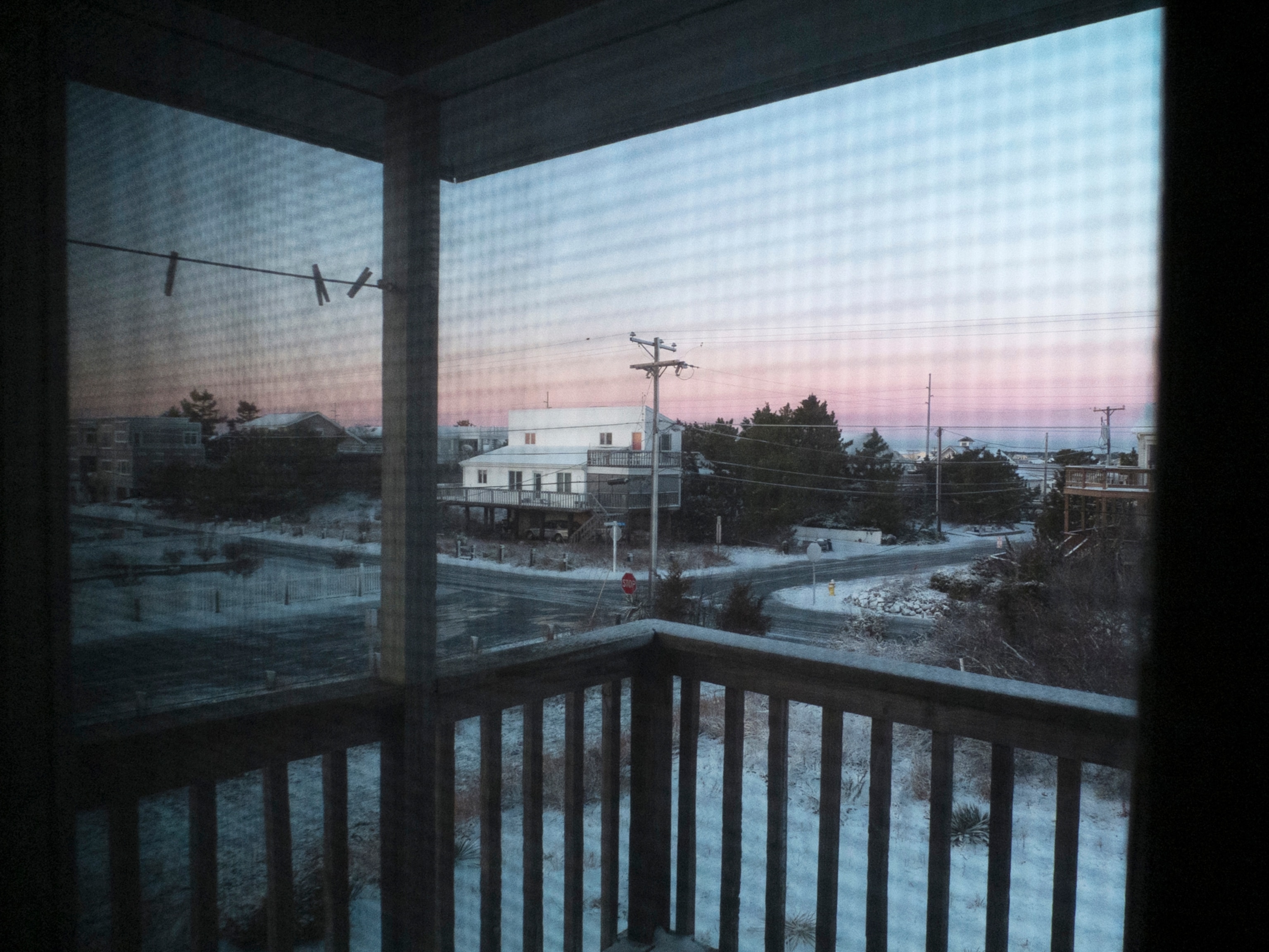 a street in a beach neighborhood, seen from the deck of a beach house at sunset