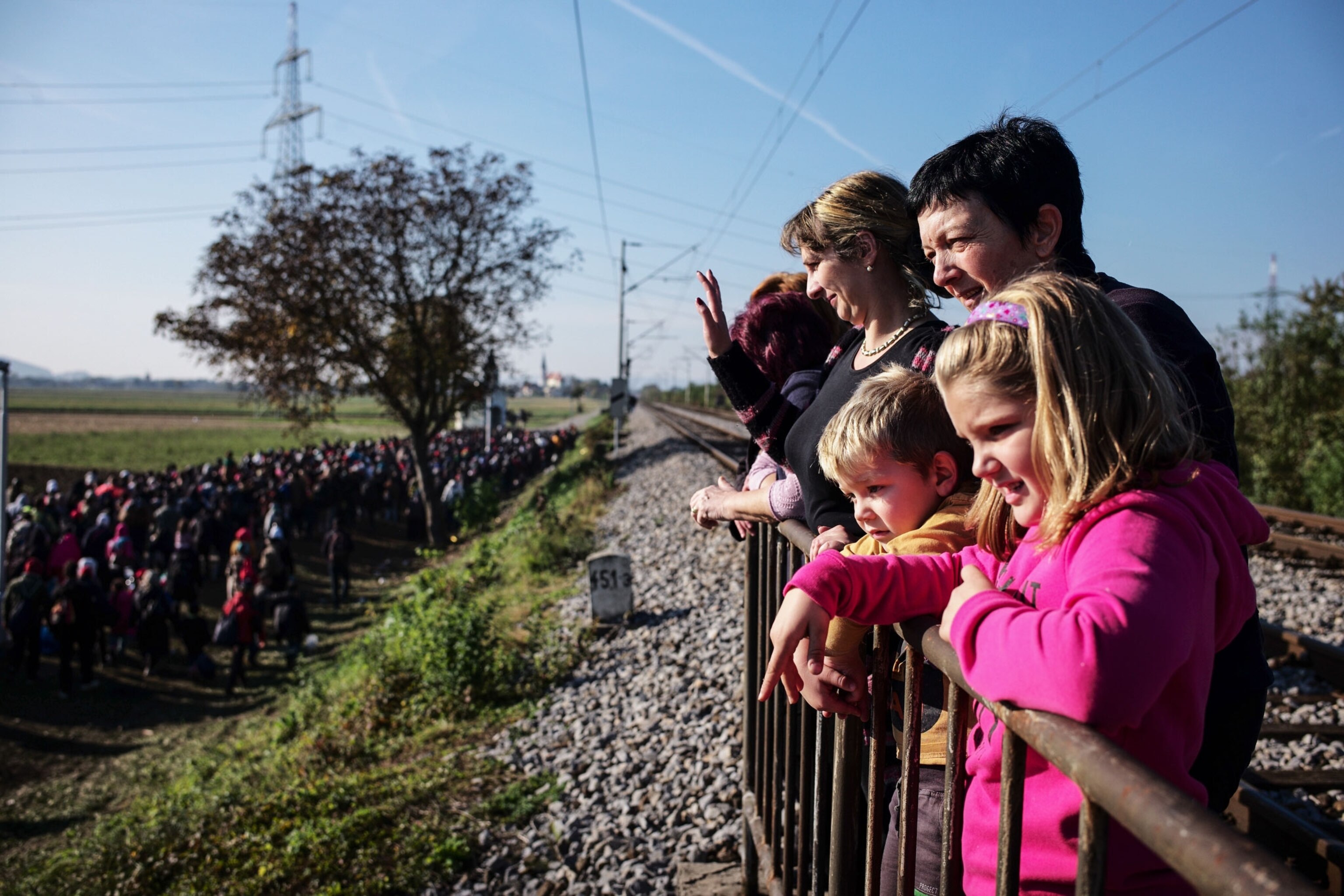 locals waving at refugees