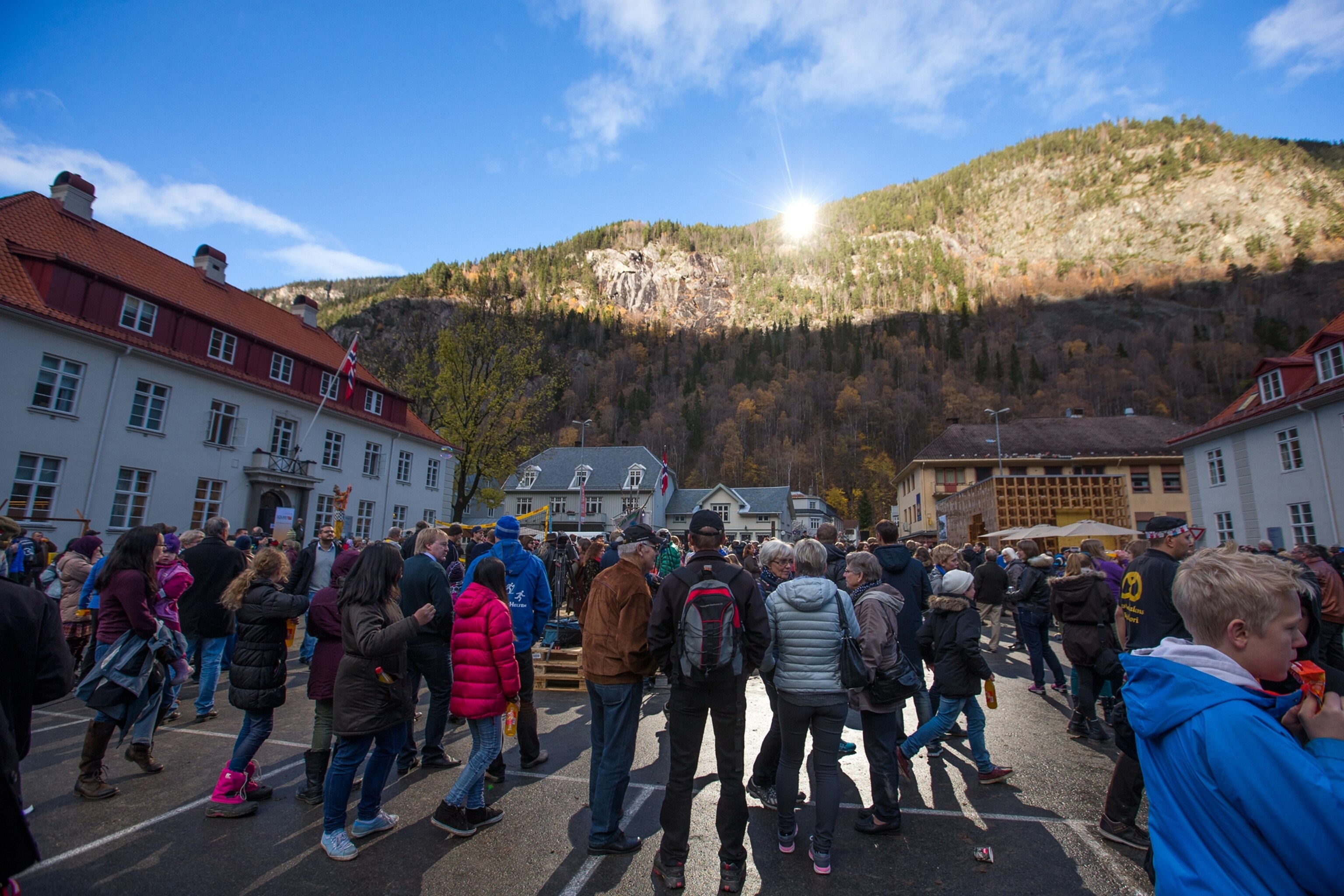 people in town square in Rjukan, Norway, gathered around a sunbeam bounced from a mirror on a mountain