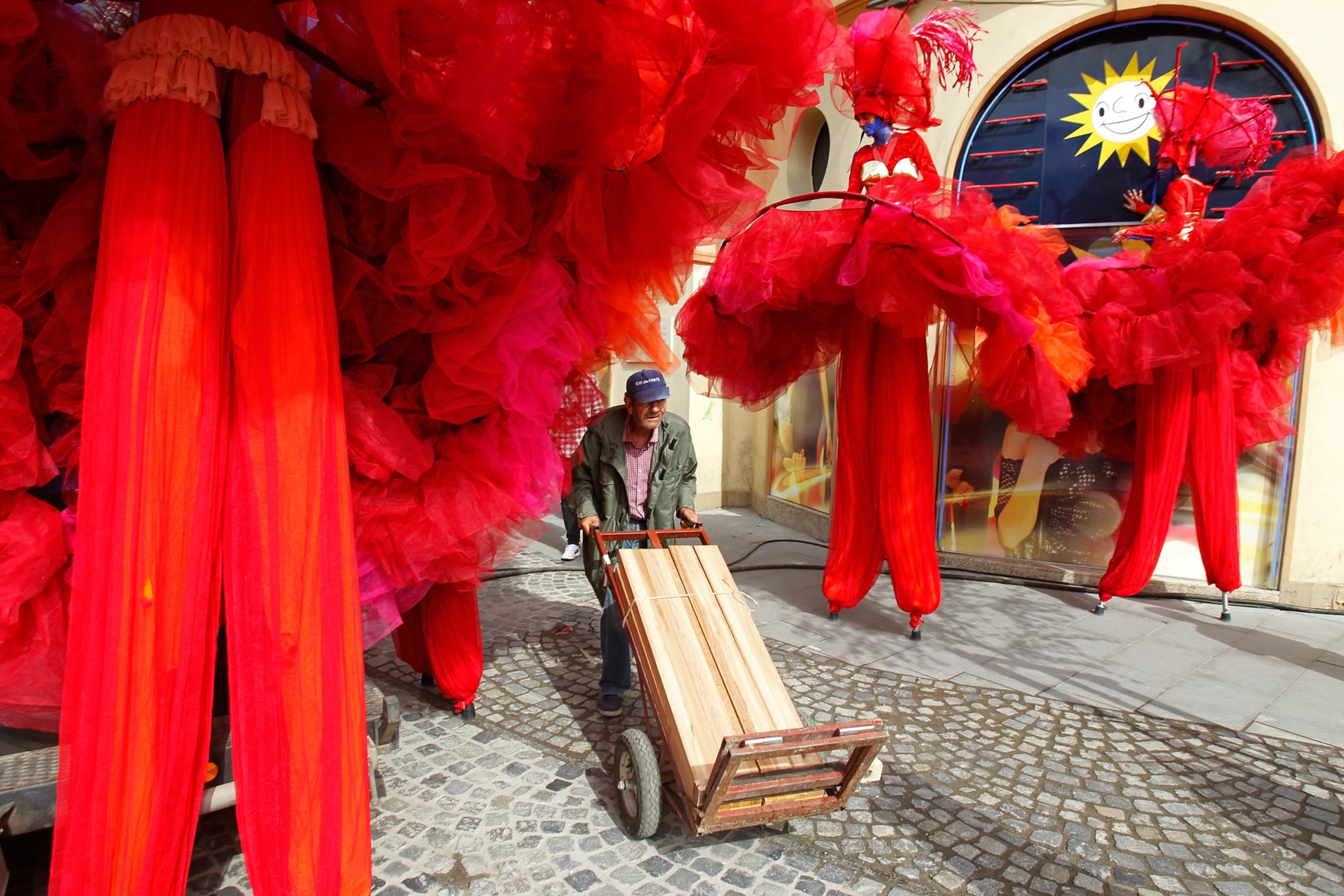a man pushing a cart through a parade in Bucharest, Romania