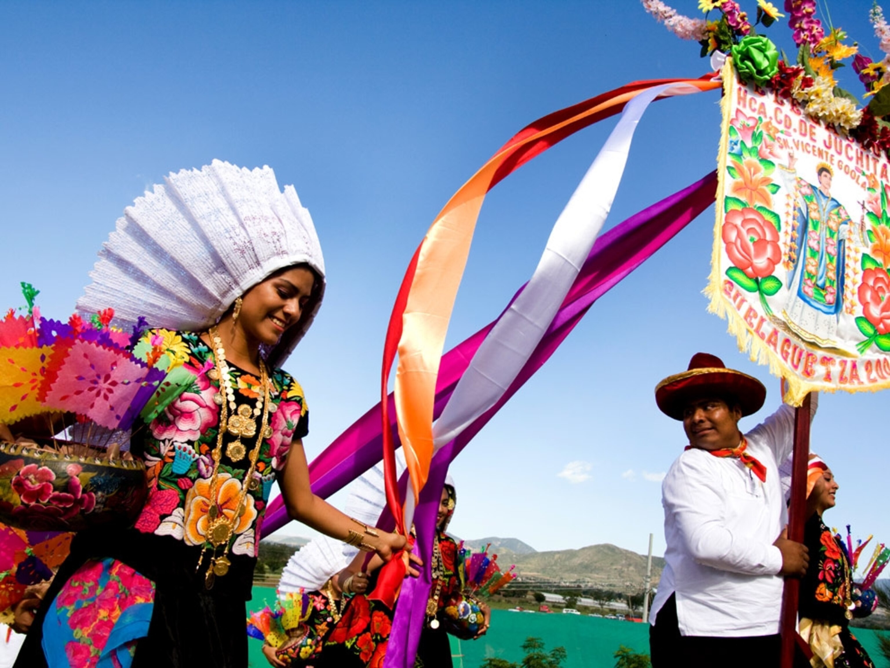 A dancer in colorful costume with streamers