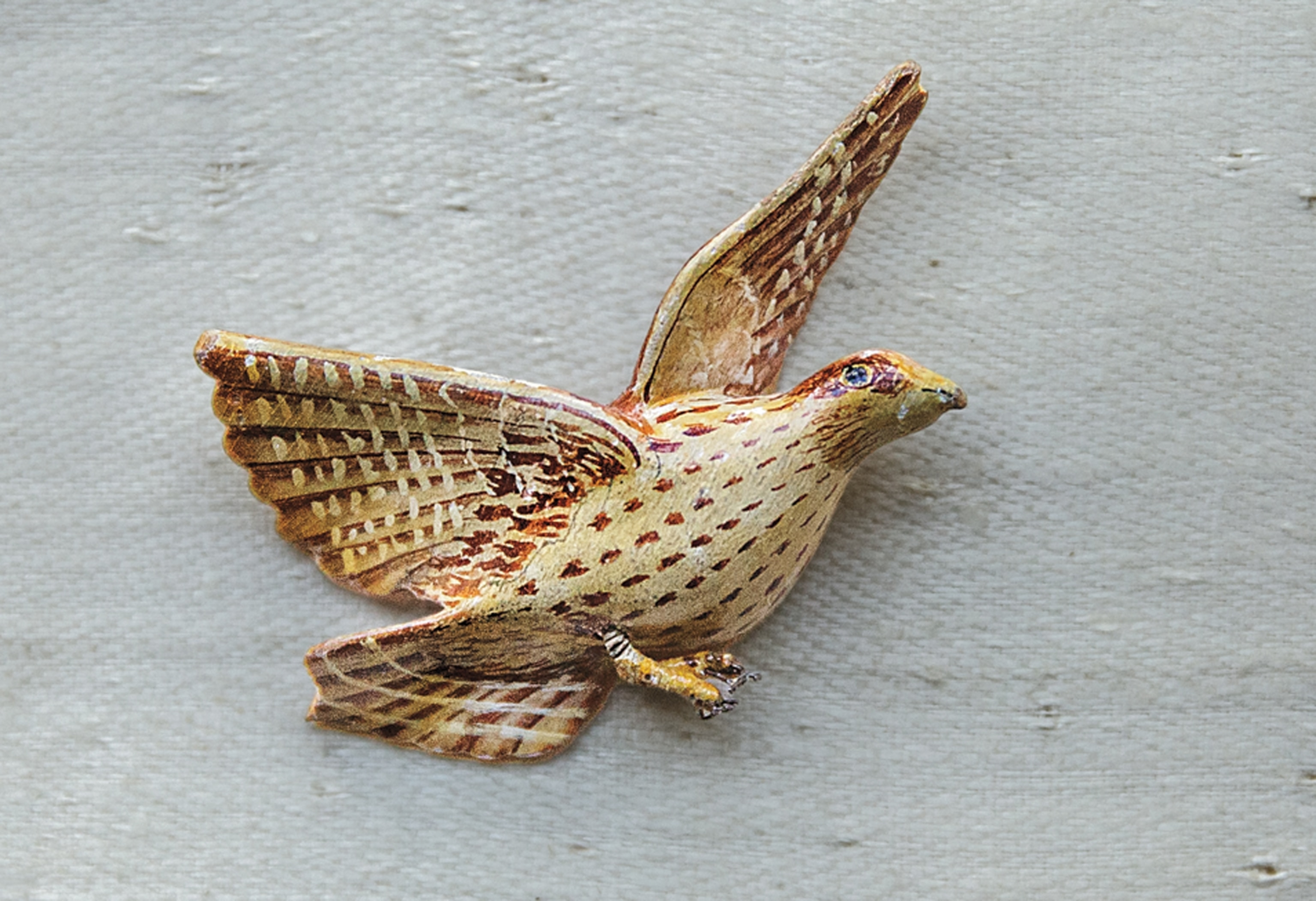 Bird figurine resembling flying partridge.