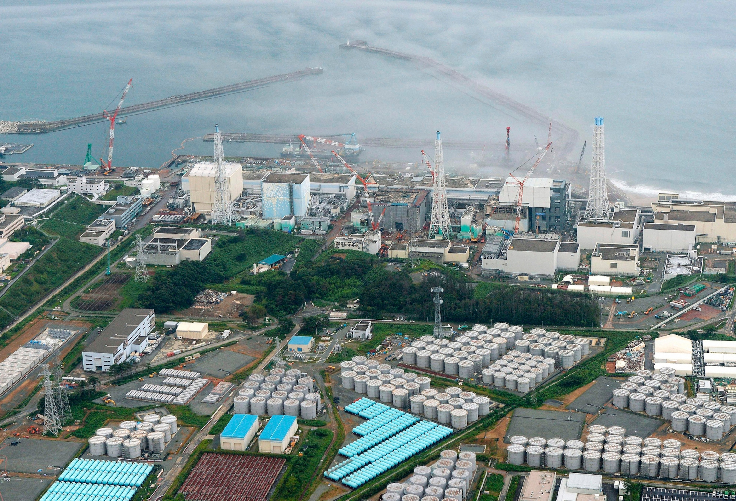 An aerial view shows Tokyo Electric Power Co. (TEPCO)'s tsunami-crippled Fukushima Daiichi nuclear power plant and its contaminated water storage tanks (bottom) in Fukushima, in this photo taken by Kyodo August 20, 2013.