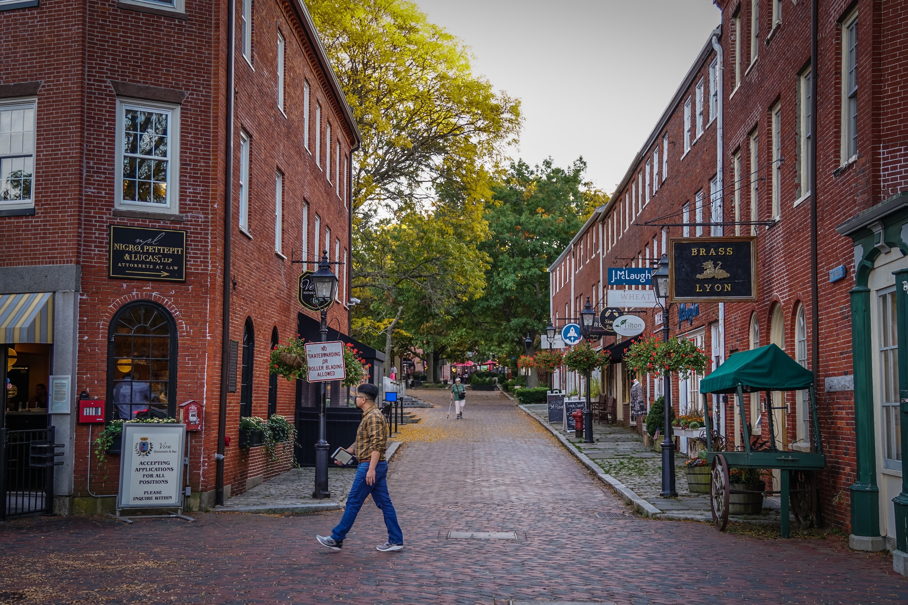 A person walks past an ally of shops in the historic district of Newburyport