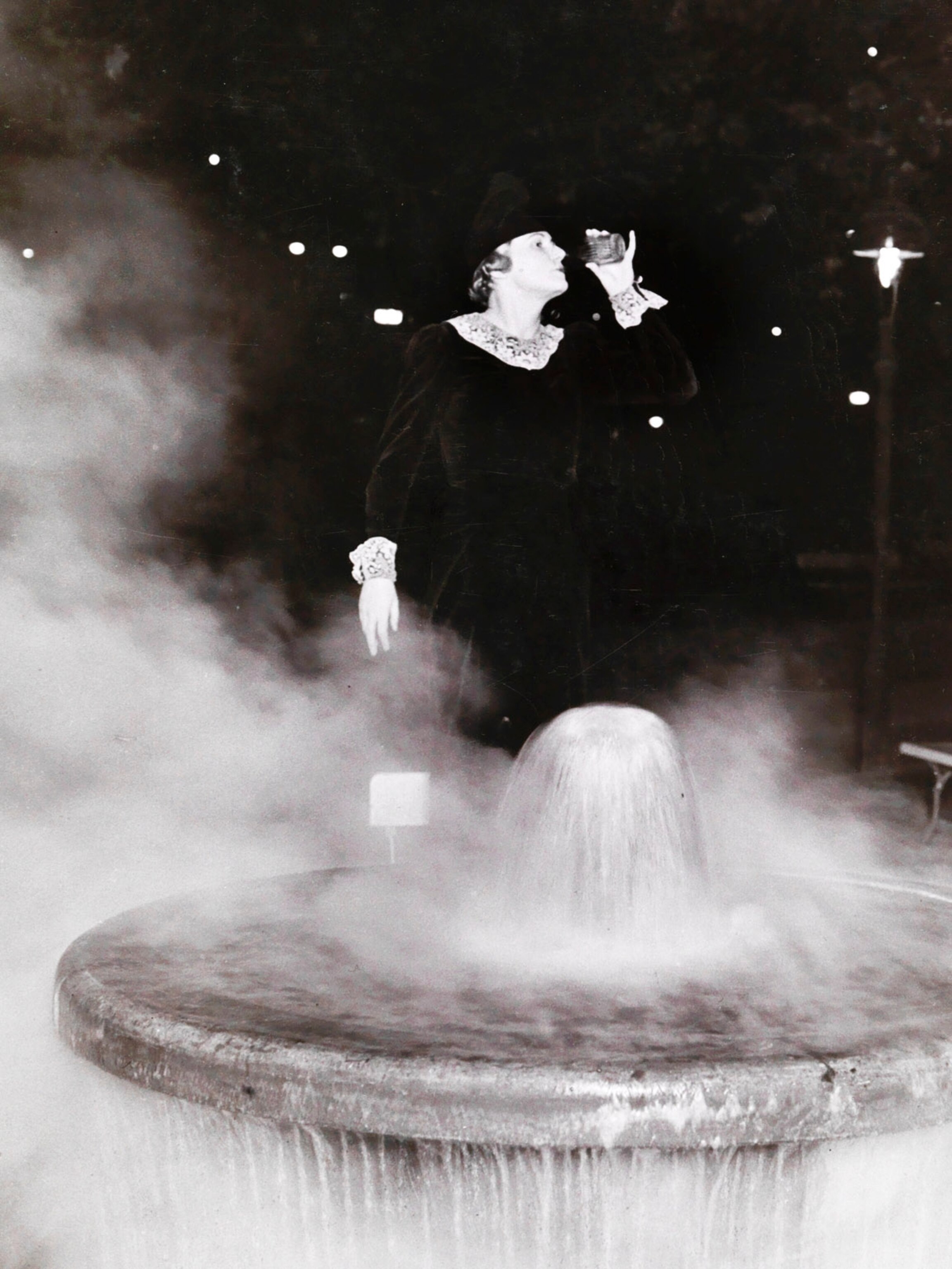Woman drinking from fountain containing radium.
