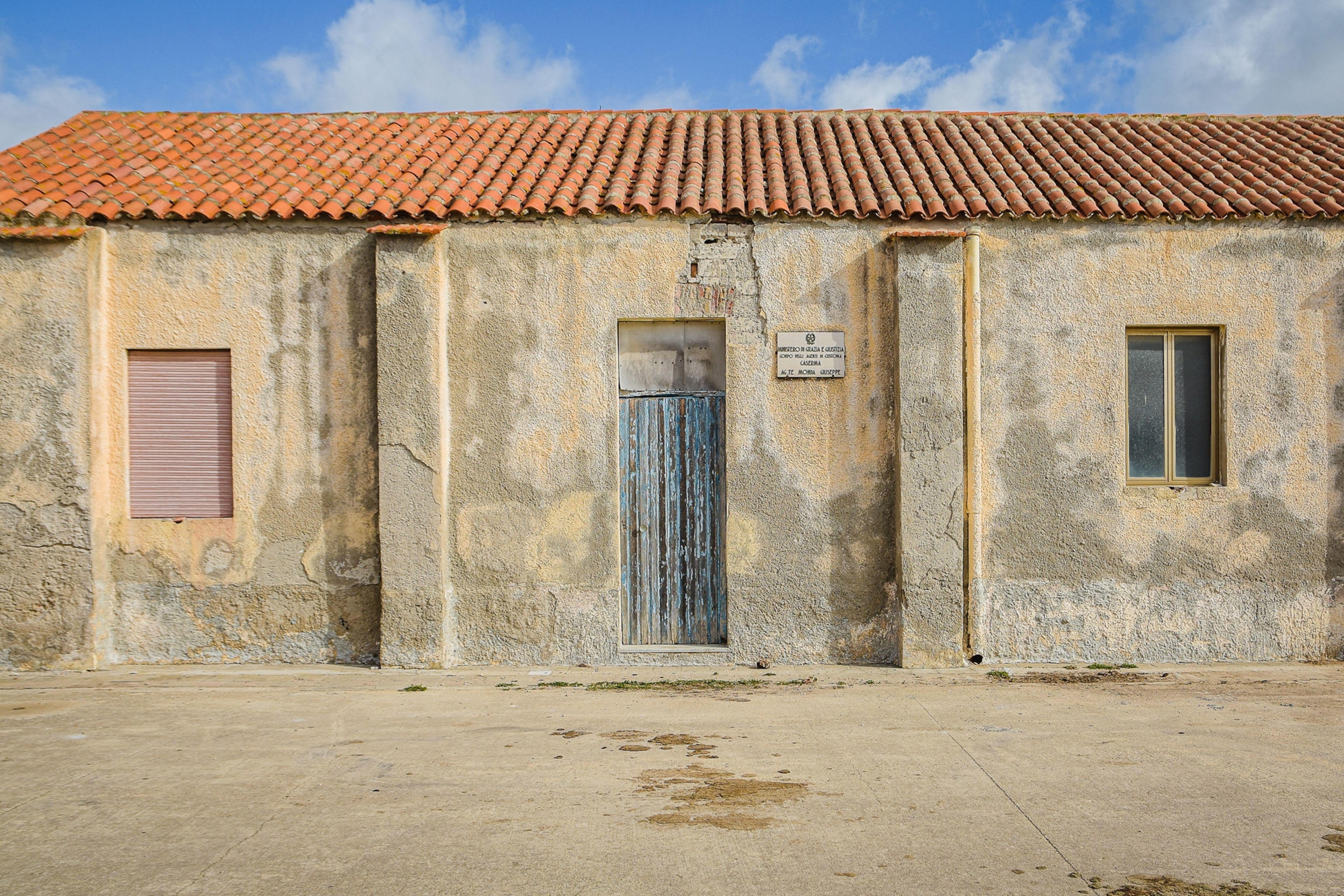 A tan and slightly eroding structure with an orange roof